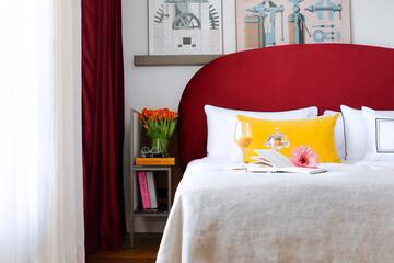 a bed with a glass of wine and a book on it