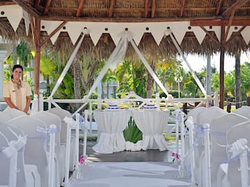 a wedding set up under a thatched roof