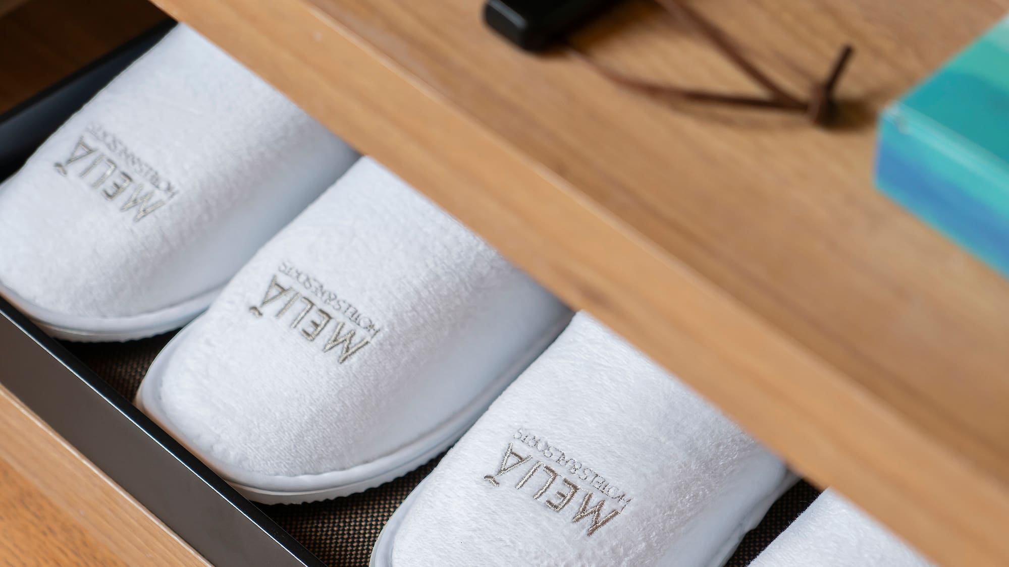 a shoe drawer with white slippers