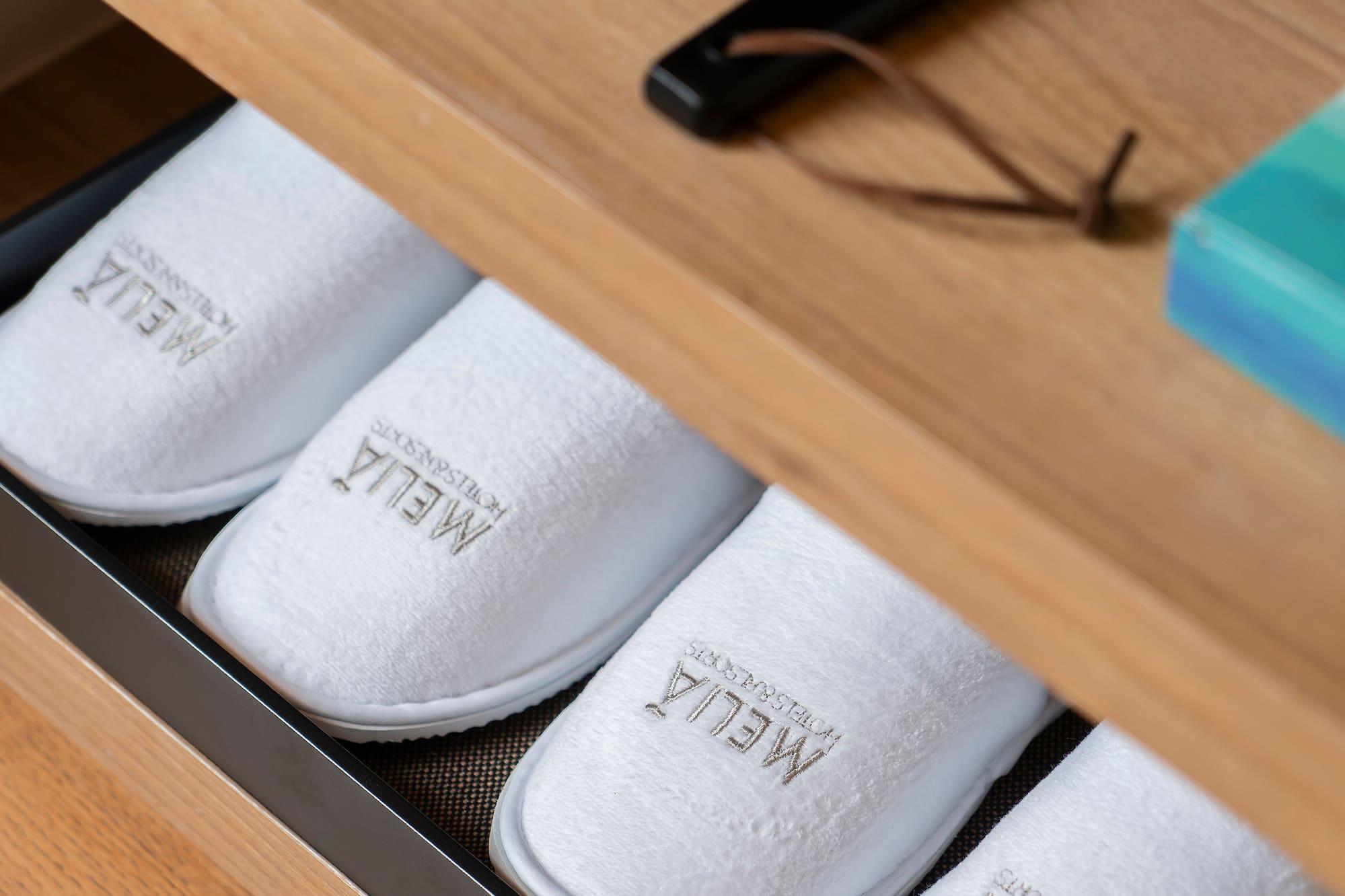 a shoe drawer with white slippers