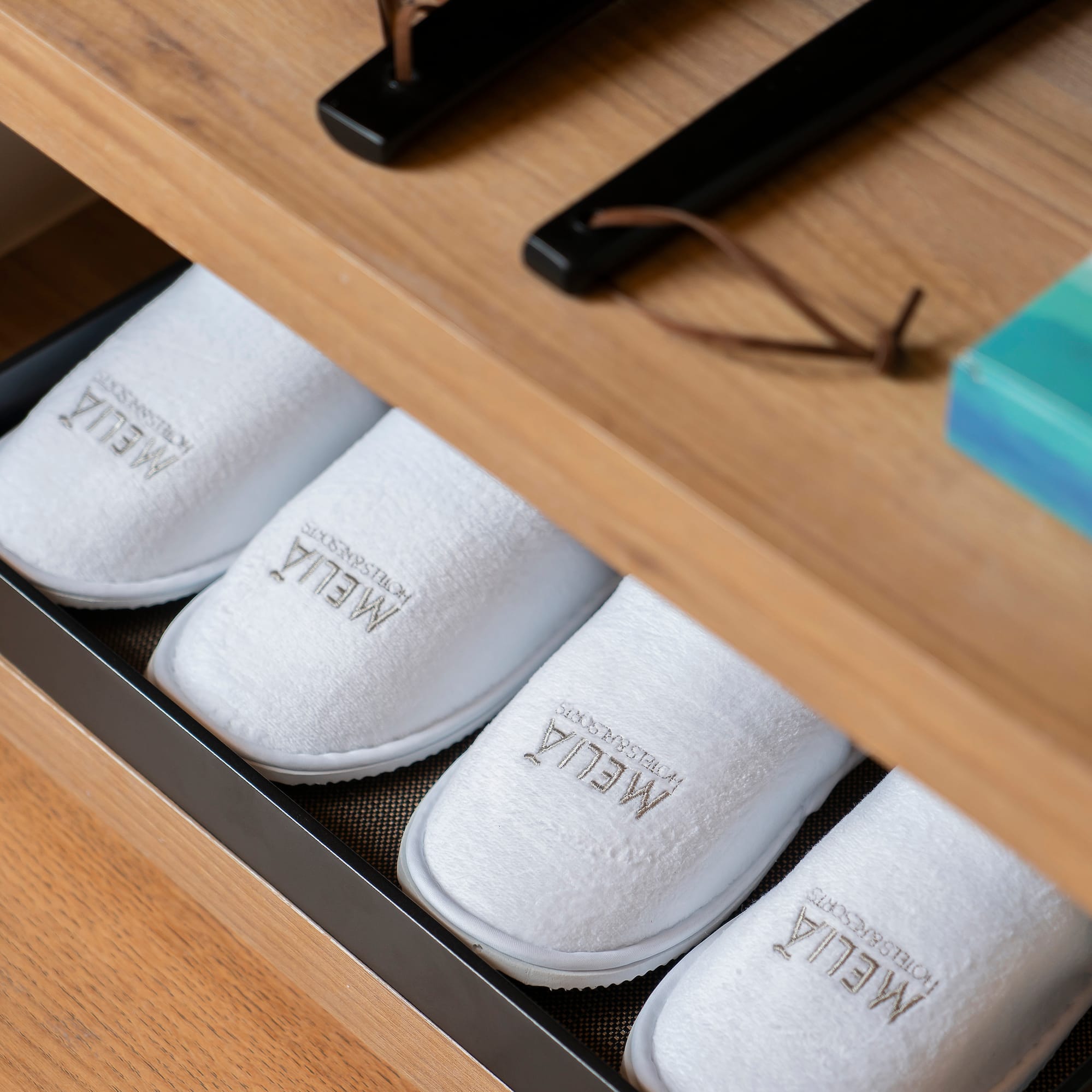 a shoe drawer with white slippers