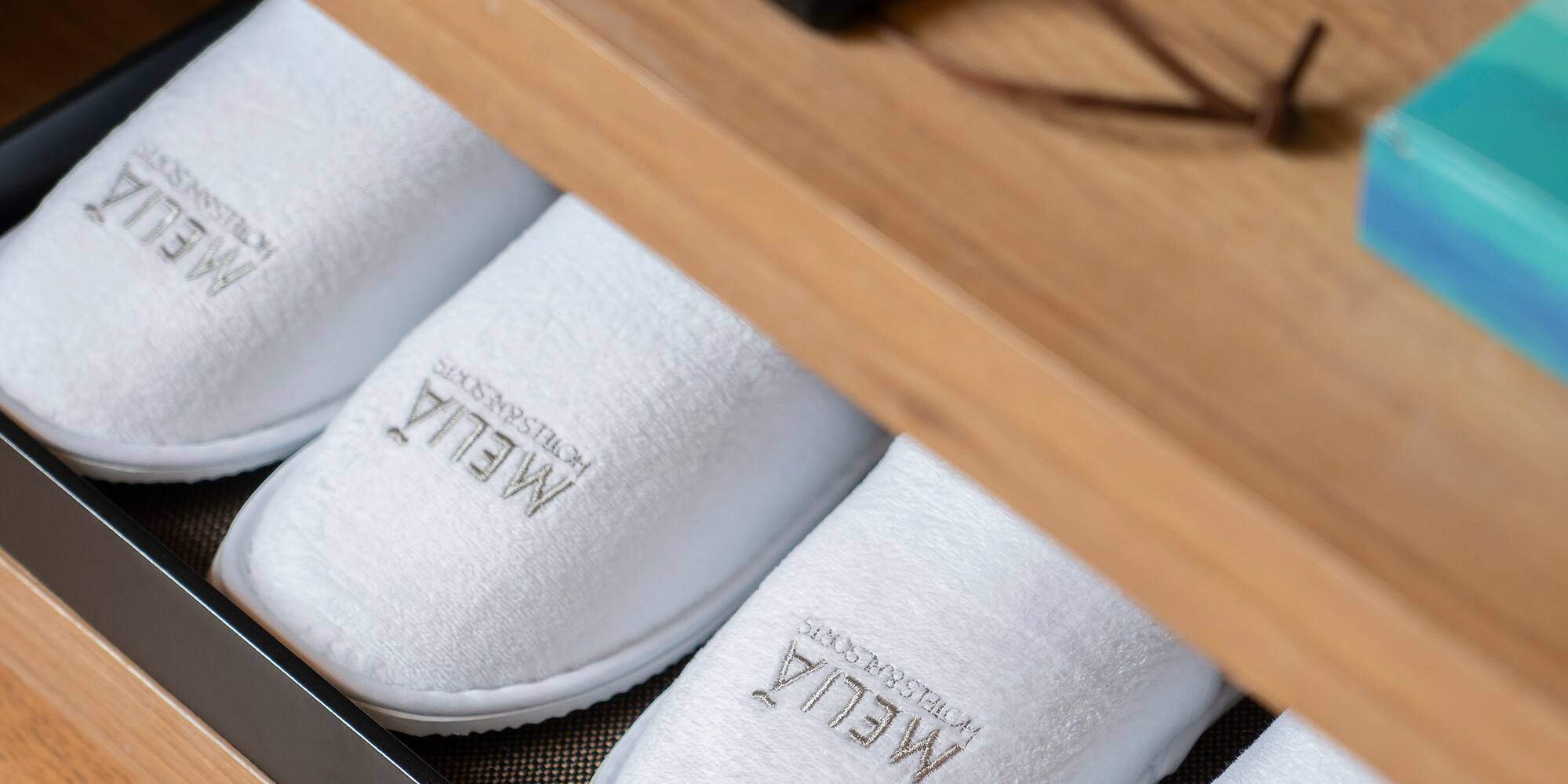 a shoe drawer with white slippers