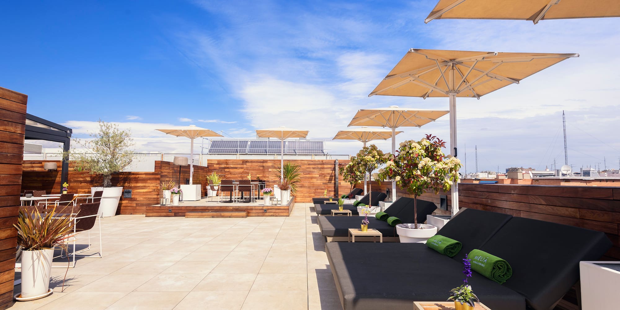 a deck with lounge chairs and umbrellas on a rooftop