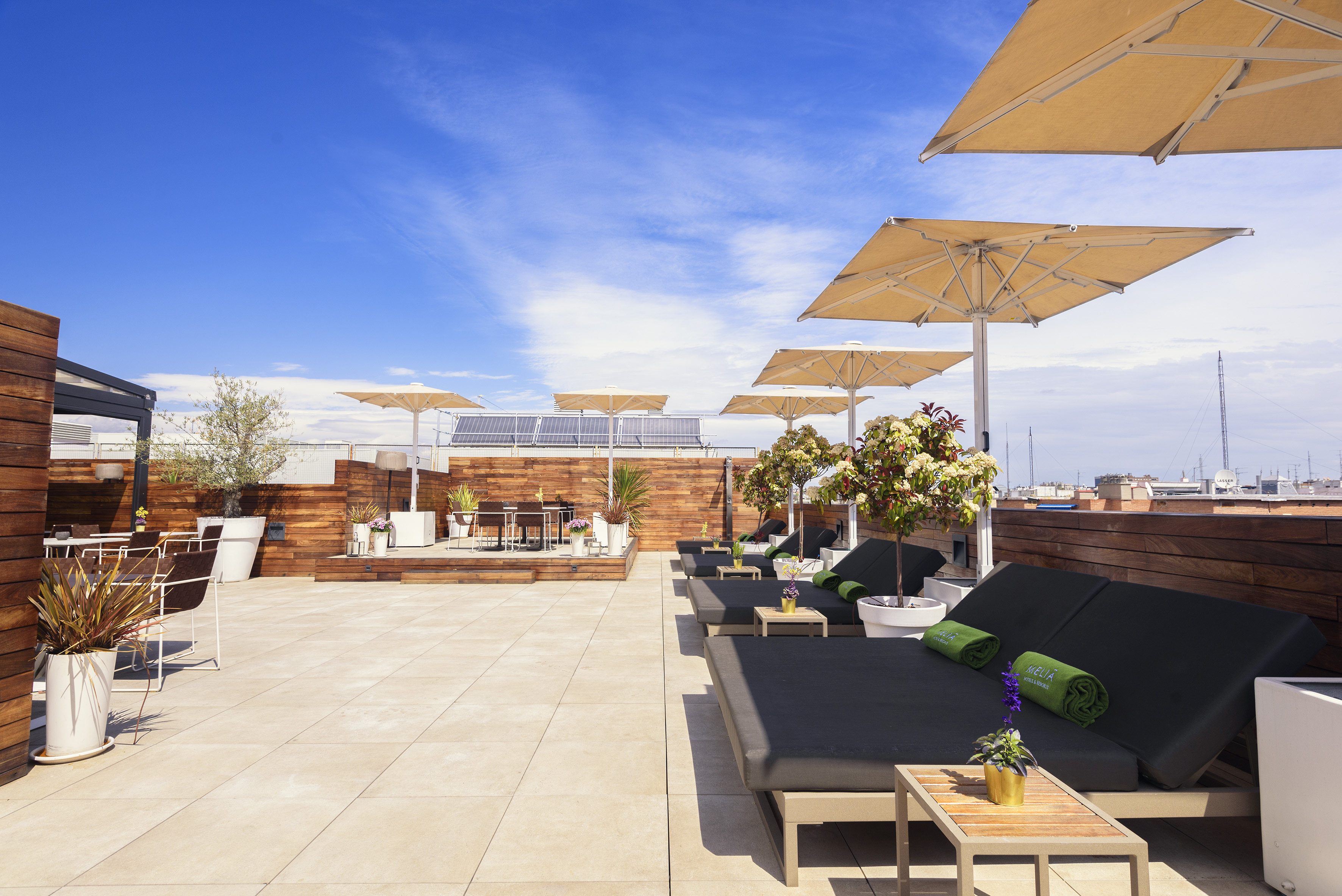 a deck with lounge chairs and umbrellas on a rooftop
