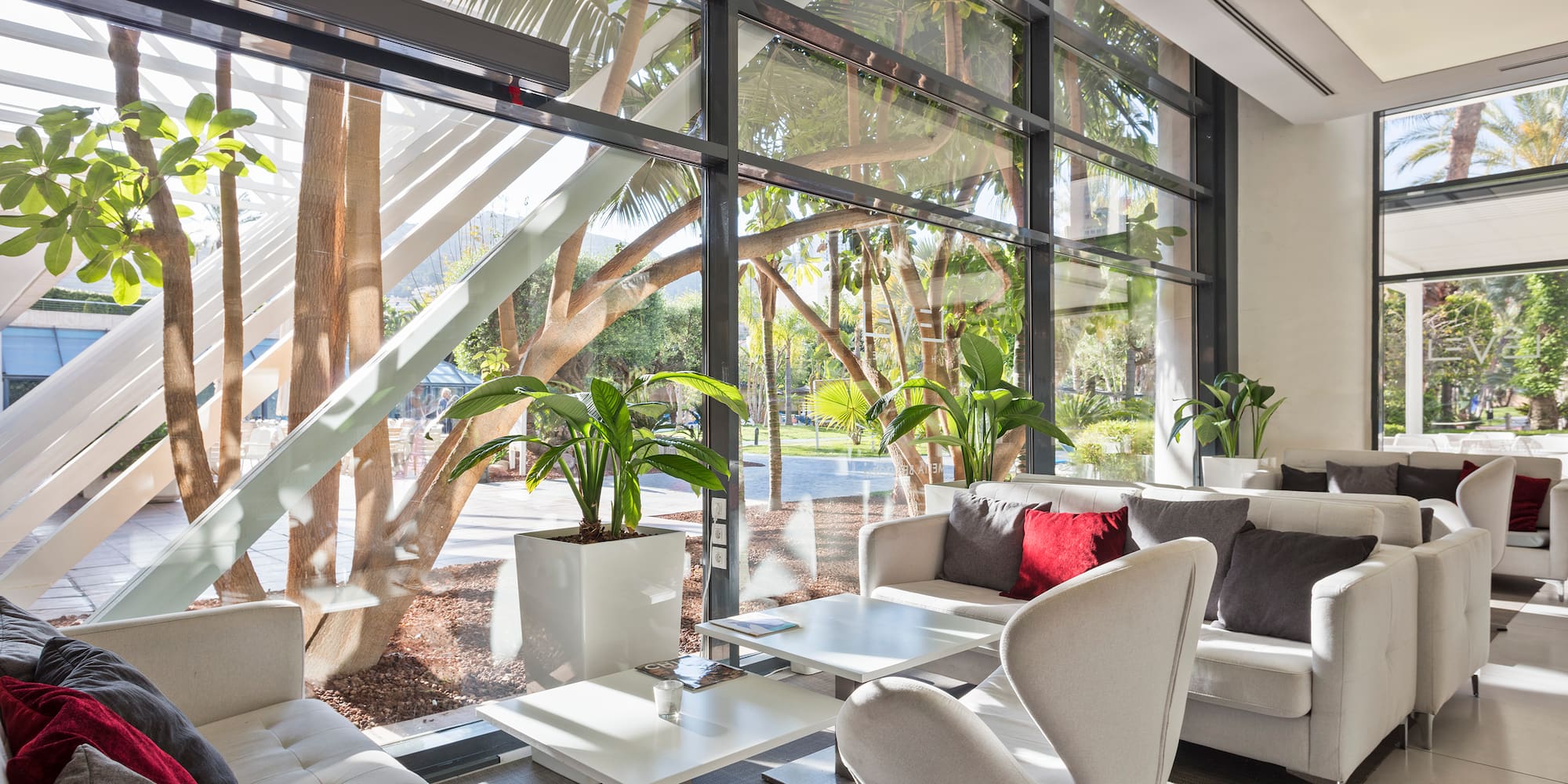 a room with white furniture and plants
