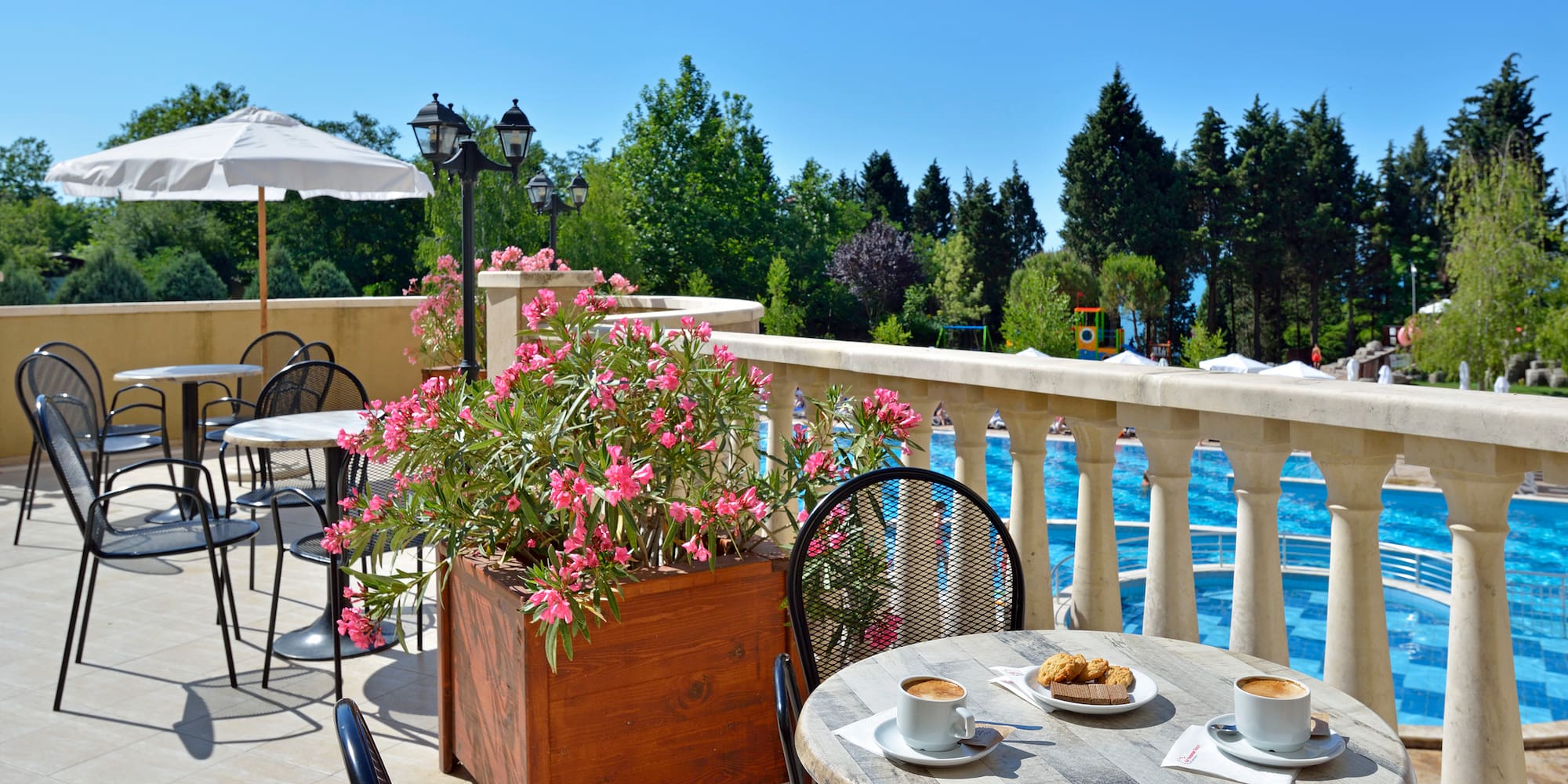 a table and chairs on a patio with a view of water and trees