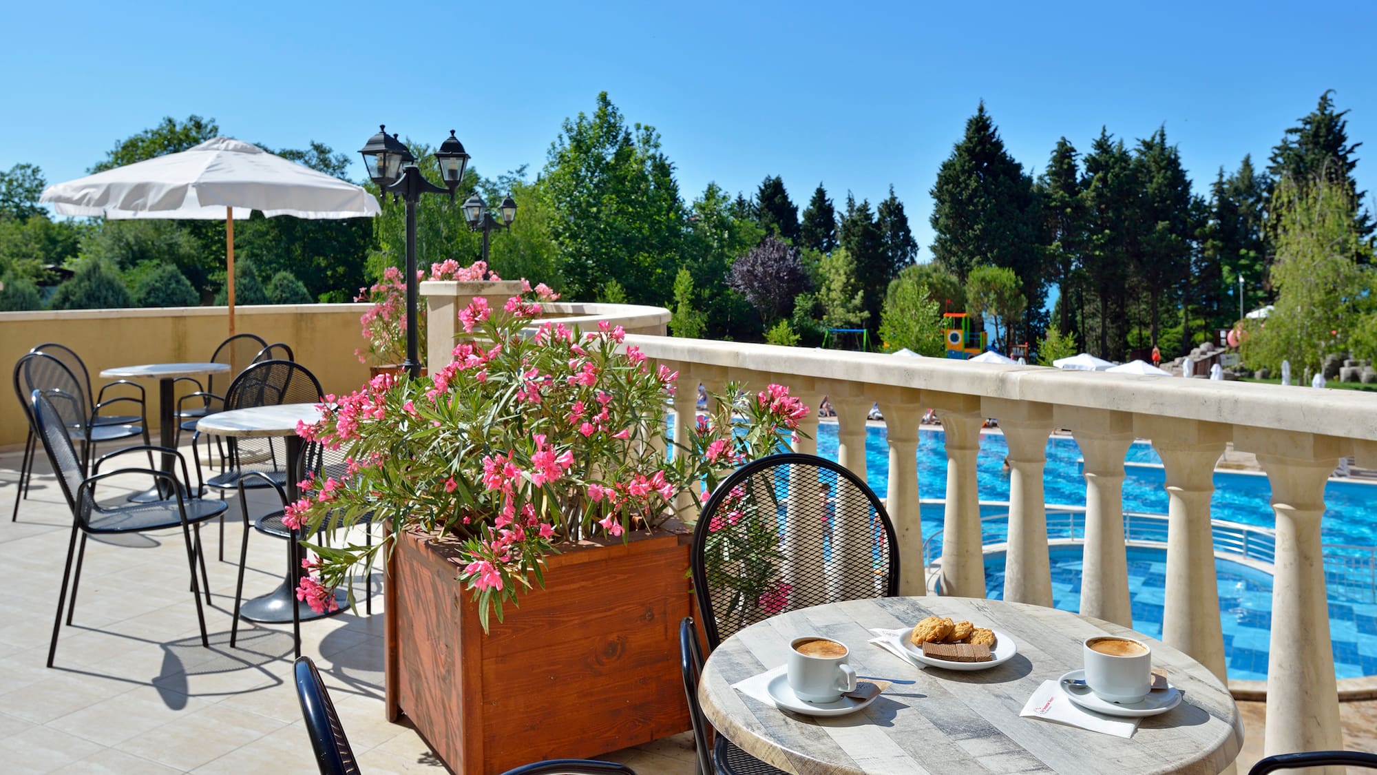 a table and chairs on a patio with a view of water and trees