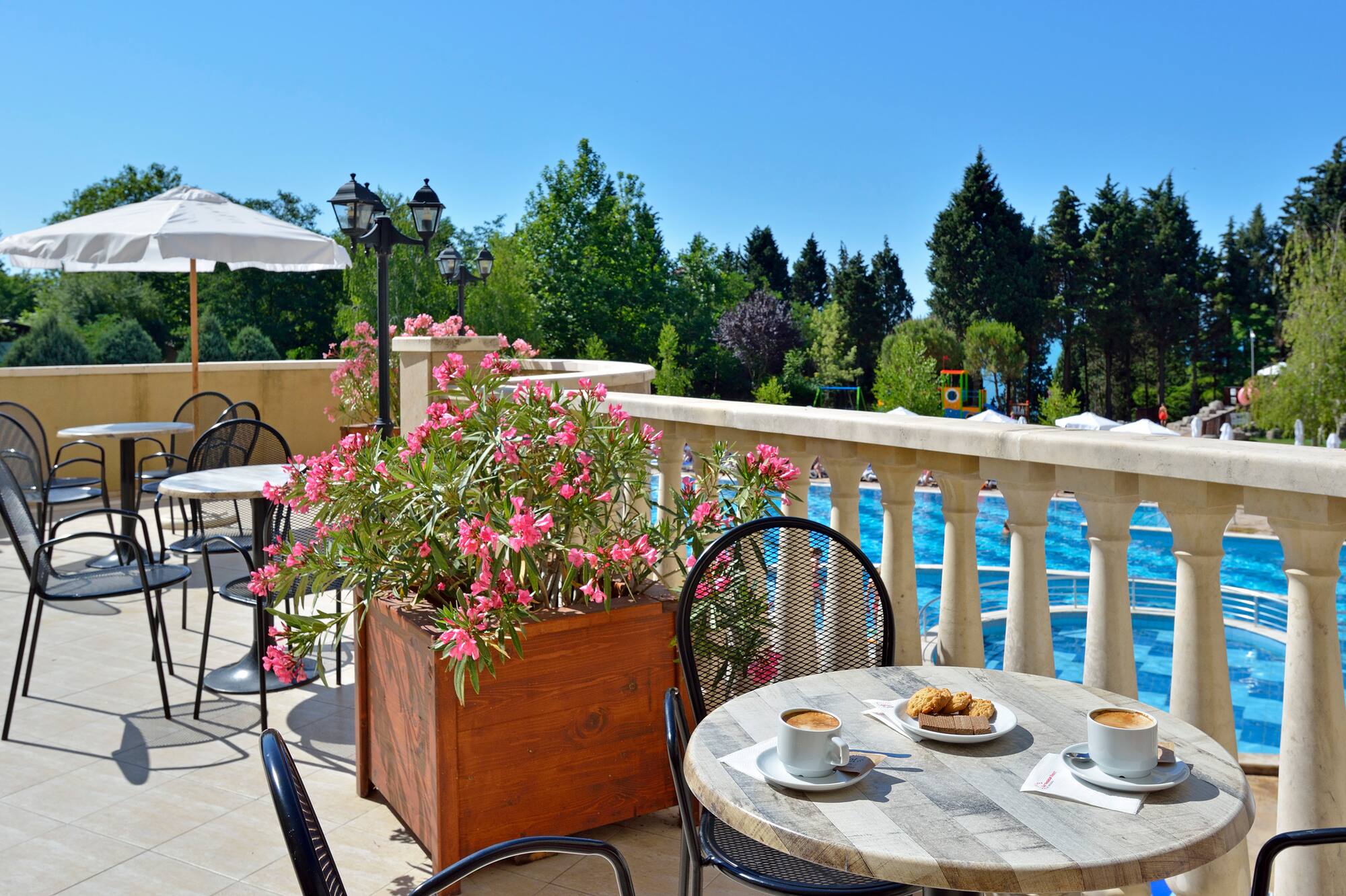 a table and chairs on a patio with a view of water and trees