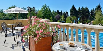 a table and chairs on a patio with a view of water and trees