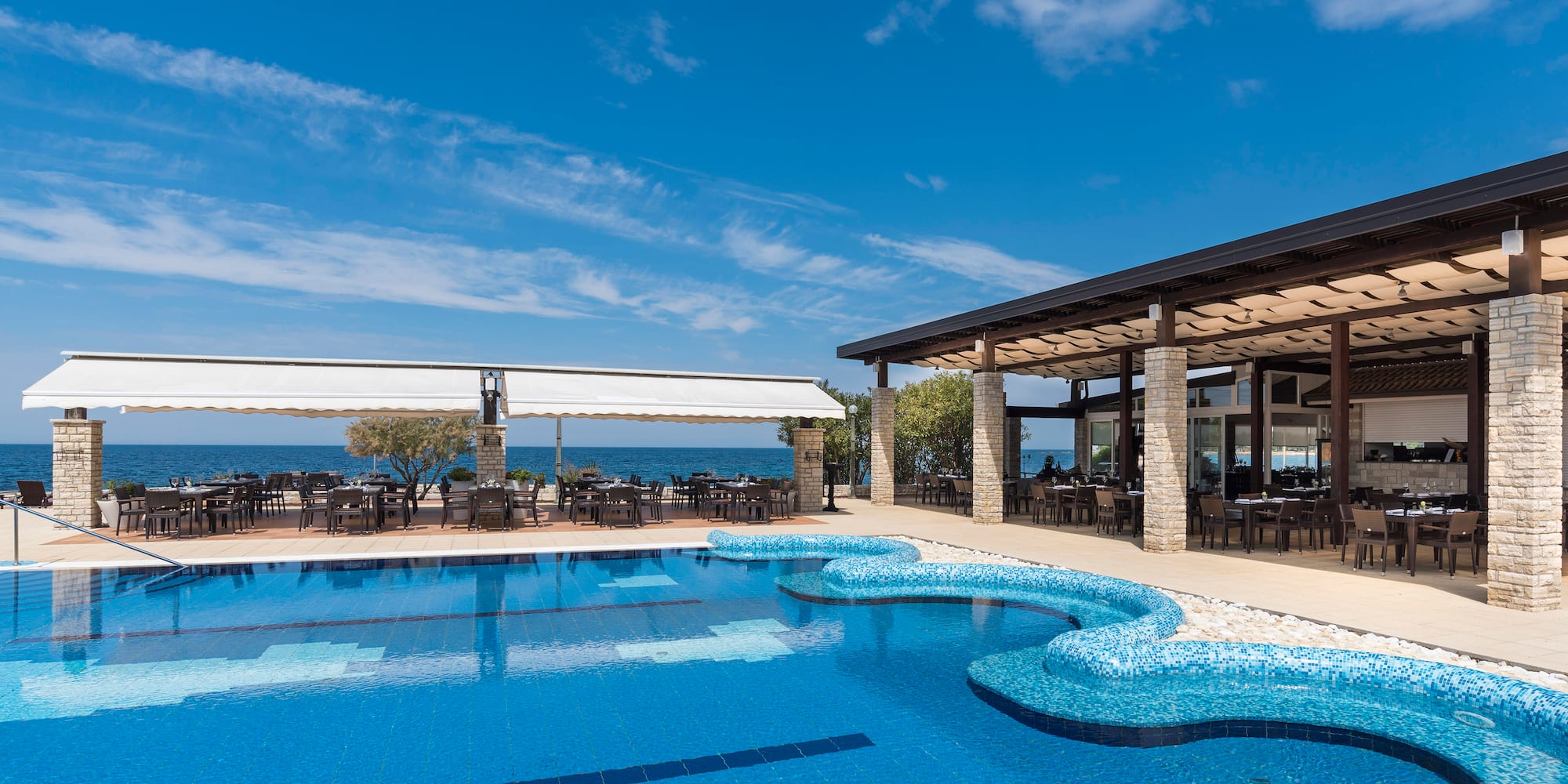 a swimming pool with tables and chairs