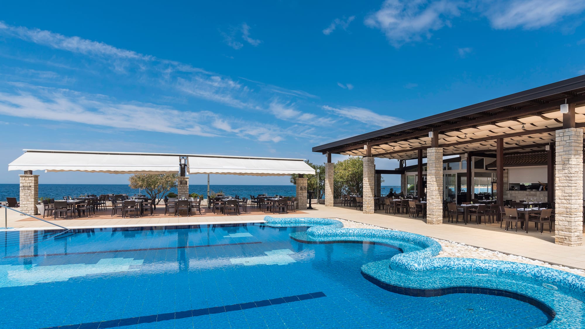 a swimming pool with tables and chairs