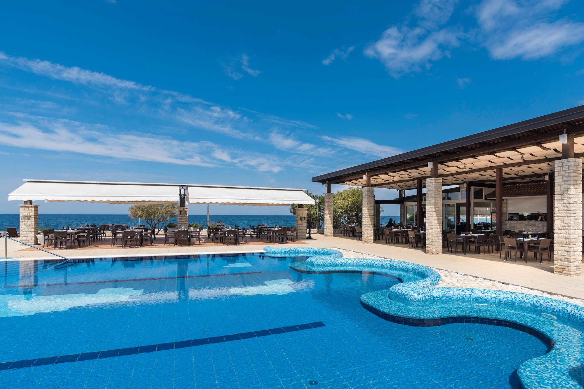 a swimming pool with tables and chairs