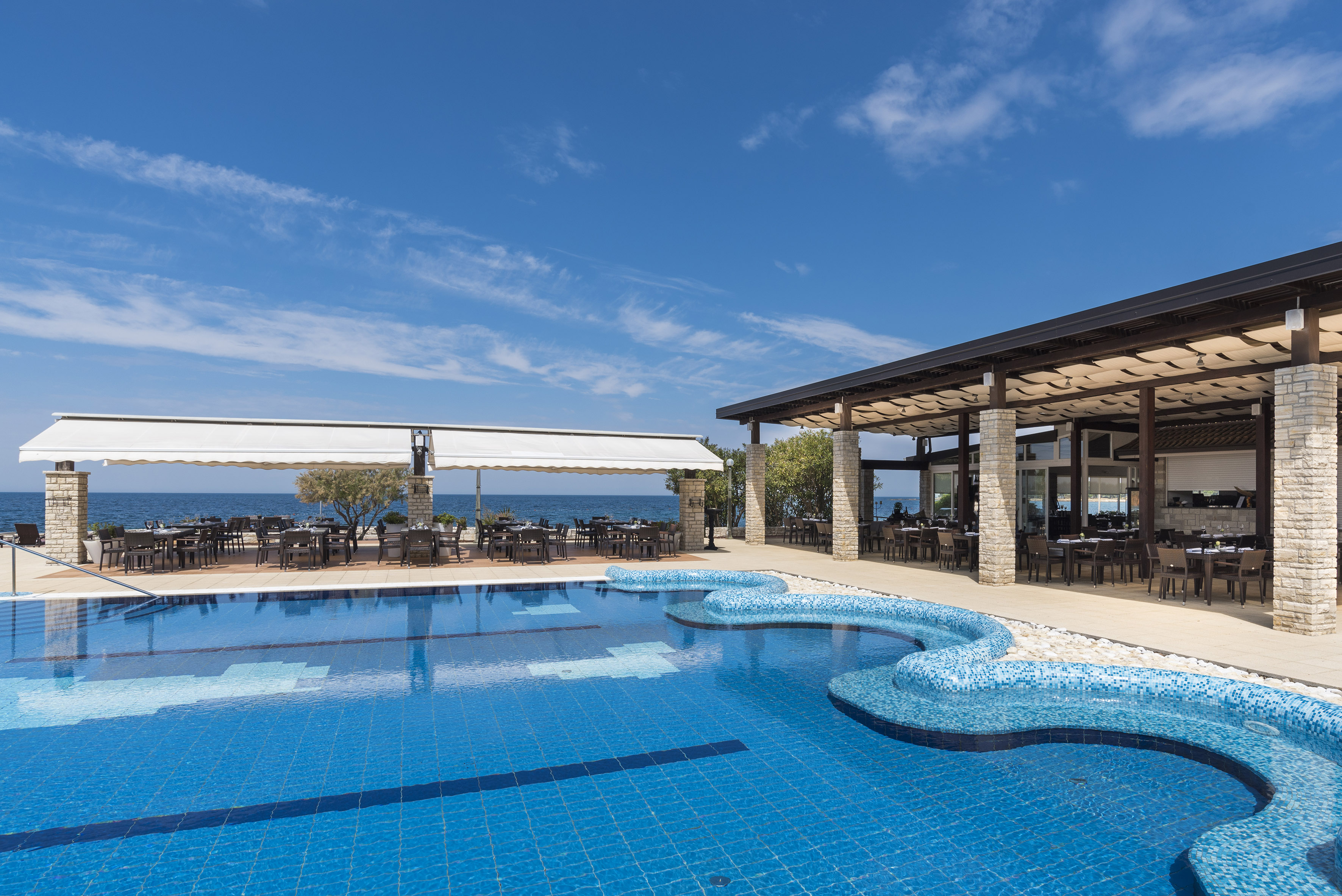a swimming pool with tables and chairs
