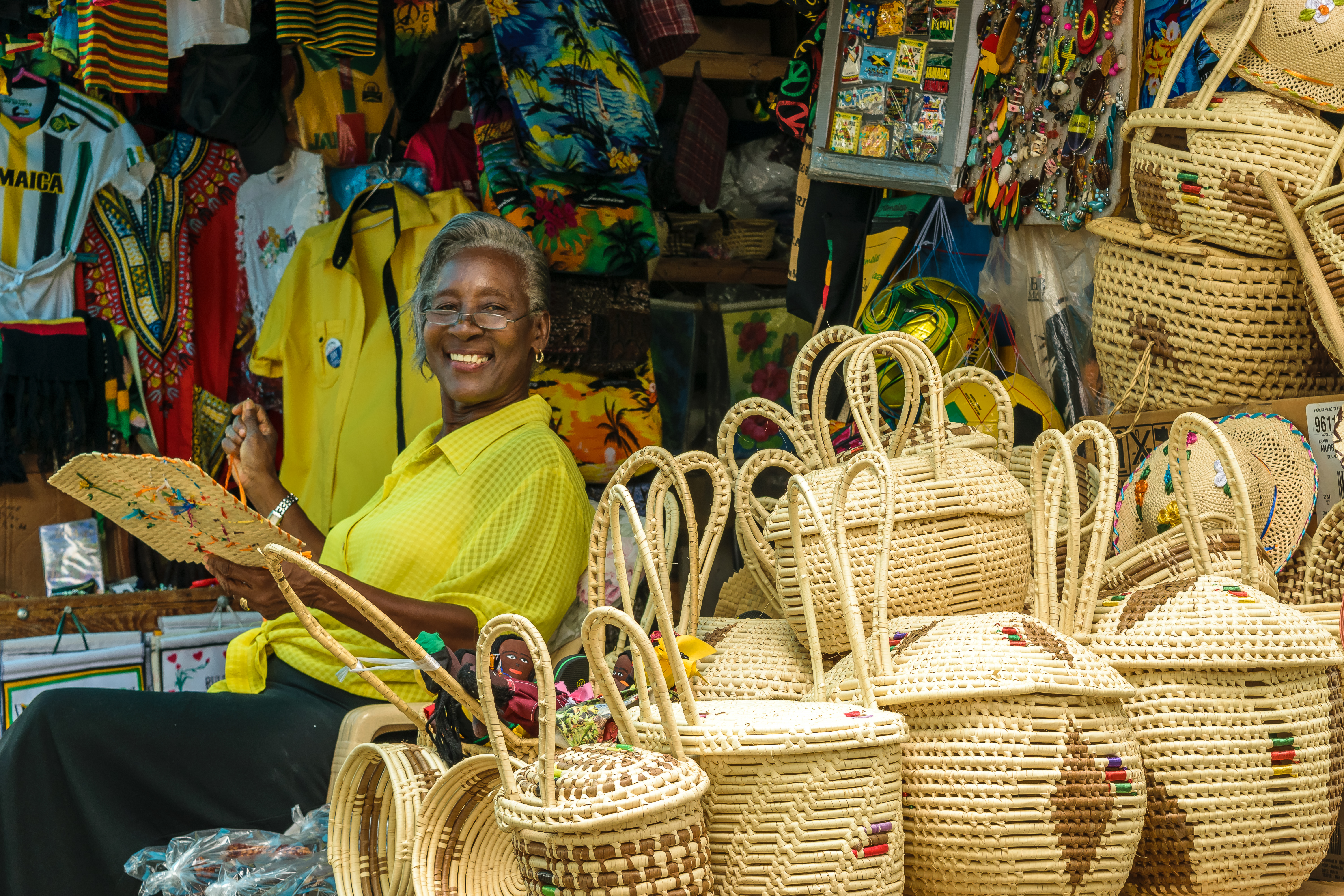 a woman sitting in front of a store with baskets