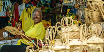a woman sitting in front of a store with baskets