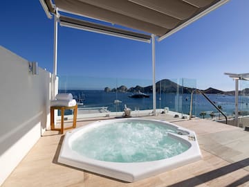 a hot tub on a deck overlooking the ocean