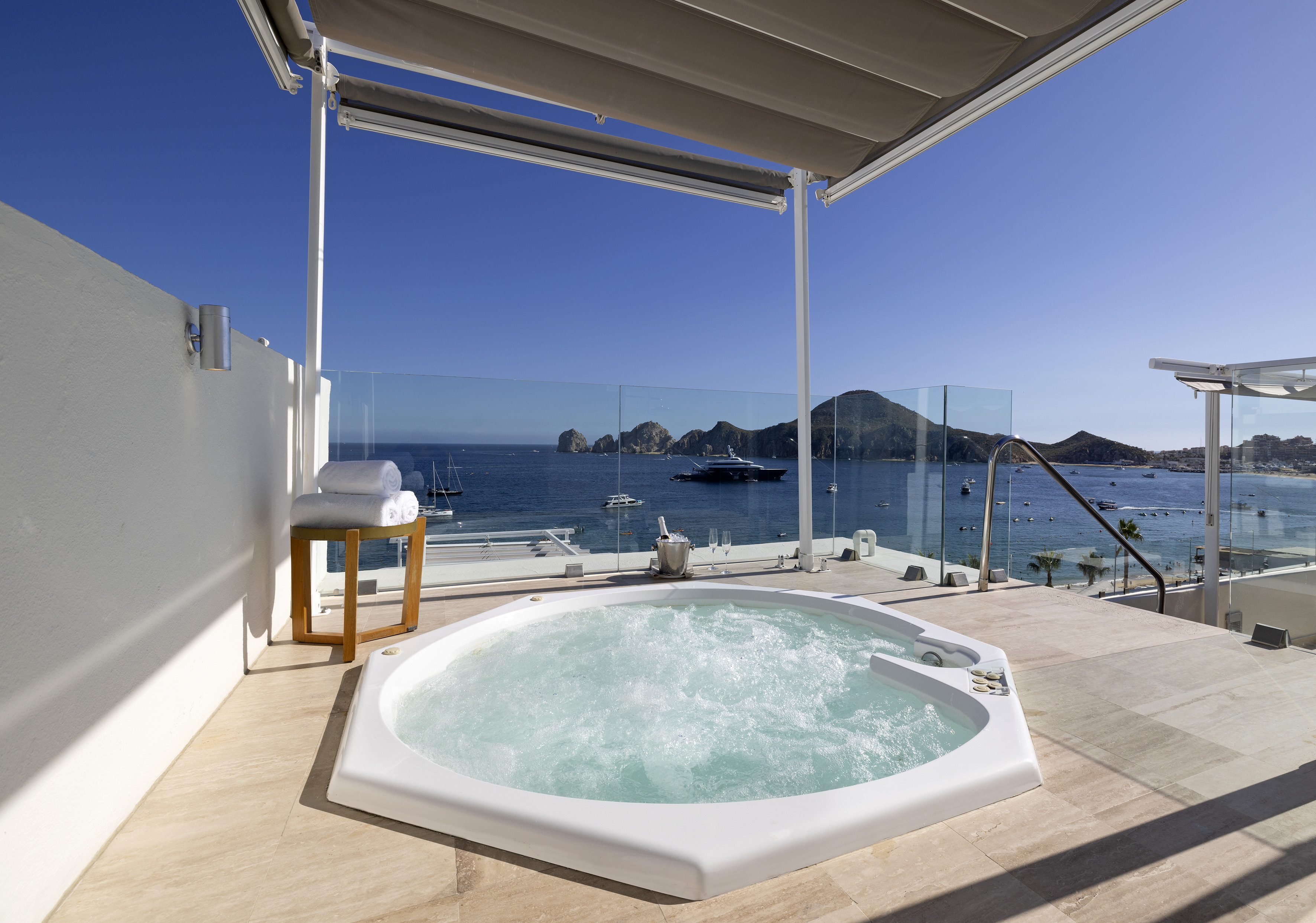 Luxury terrace hot tub with panoramic ocean views of Los Cabos and yachts.