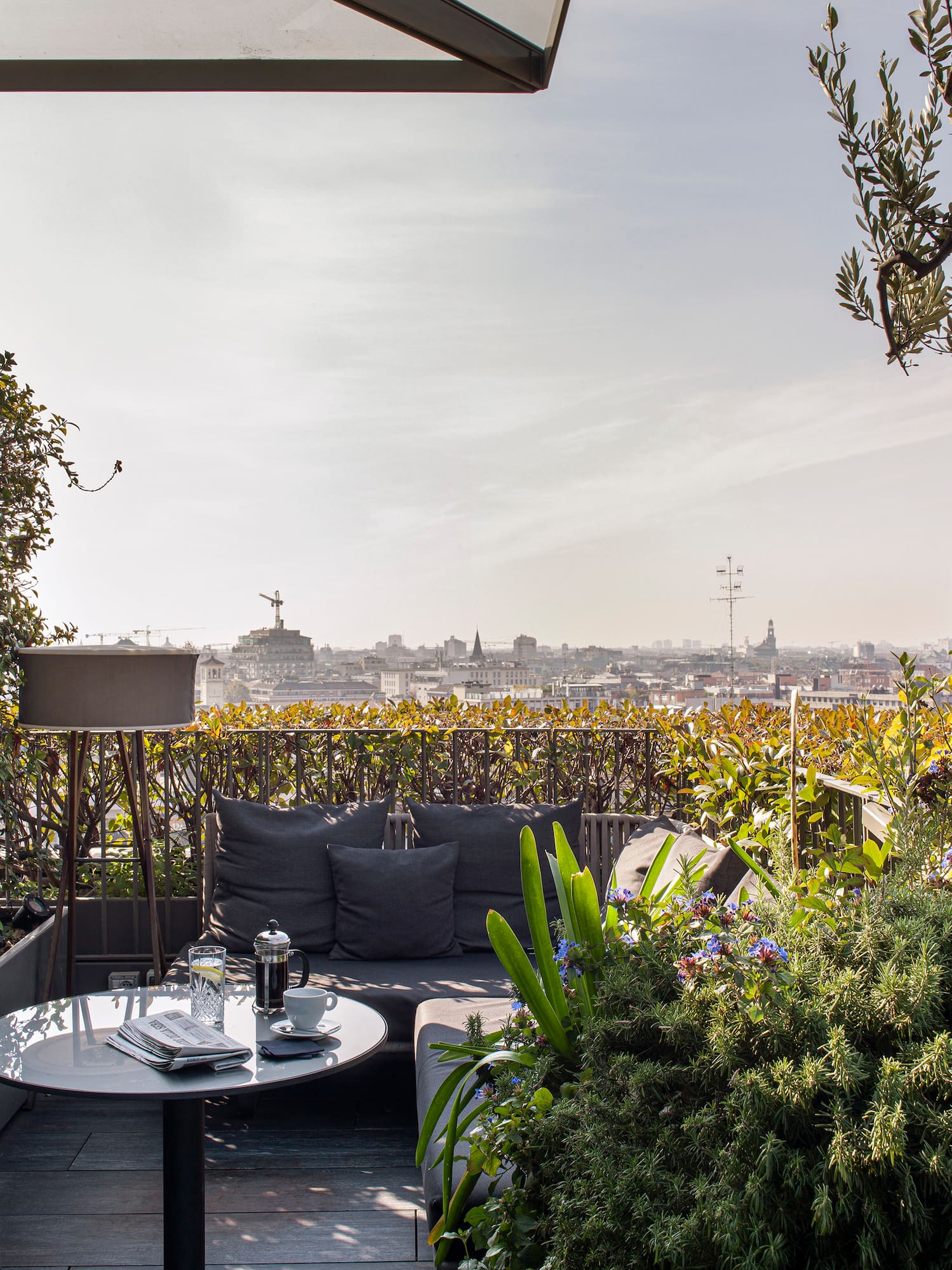 a patio with a table and chairs and a city view