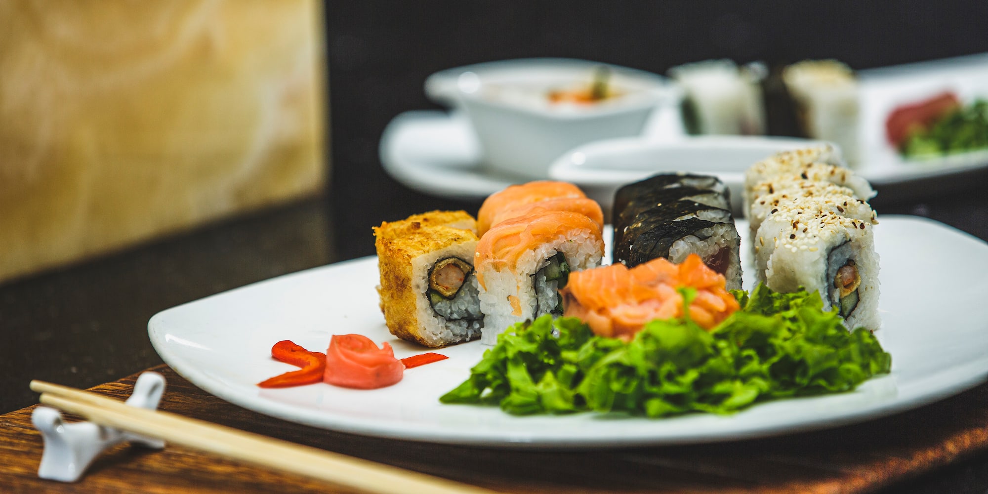 a plate of sushi with chopsticks