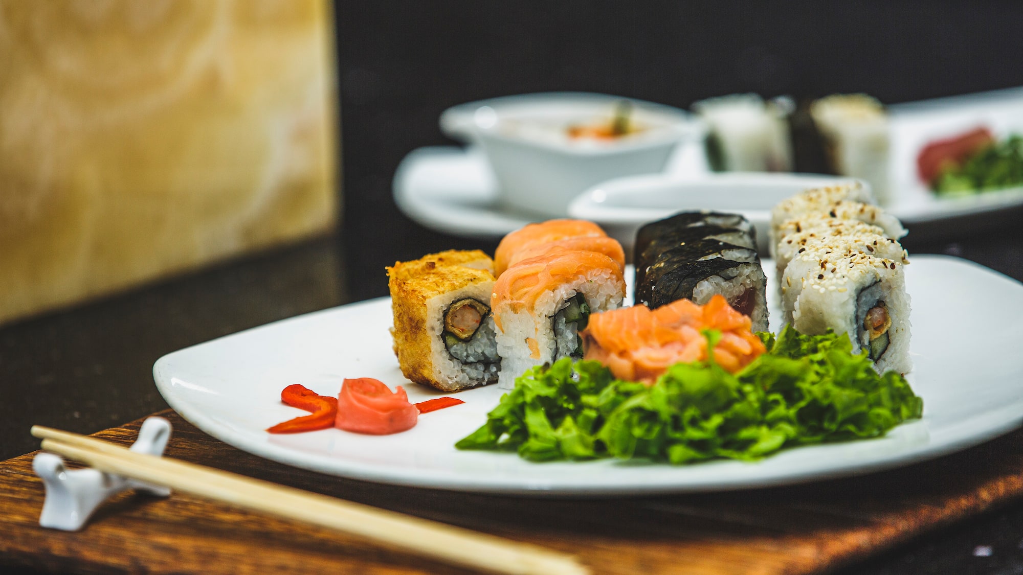 a plate of sushi with chopsticks