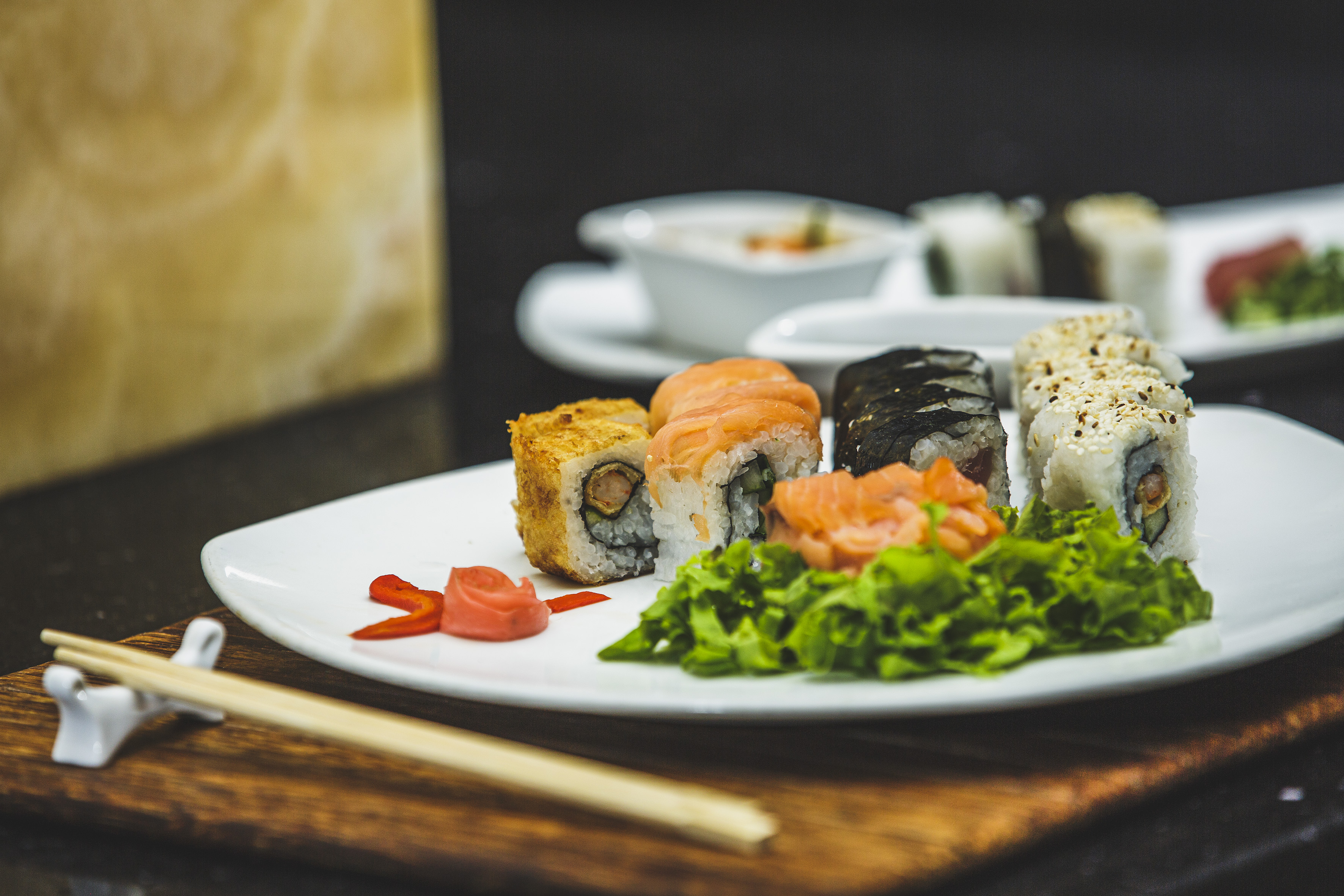 a plate of sushi with chopsticks