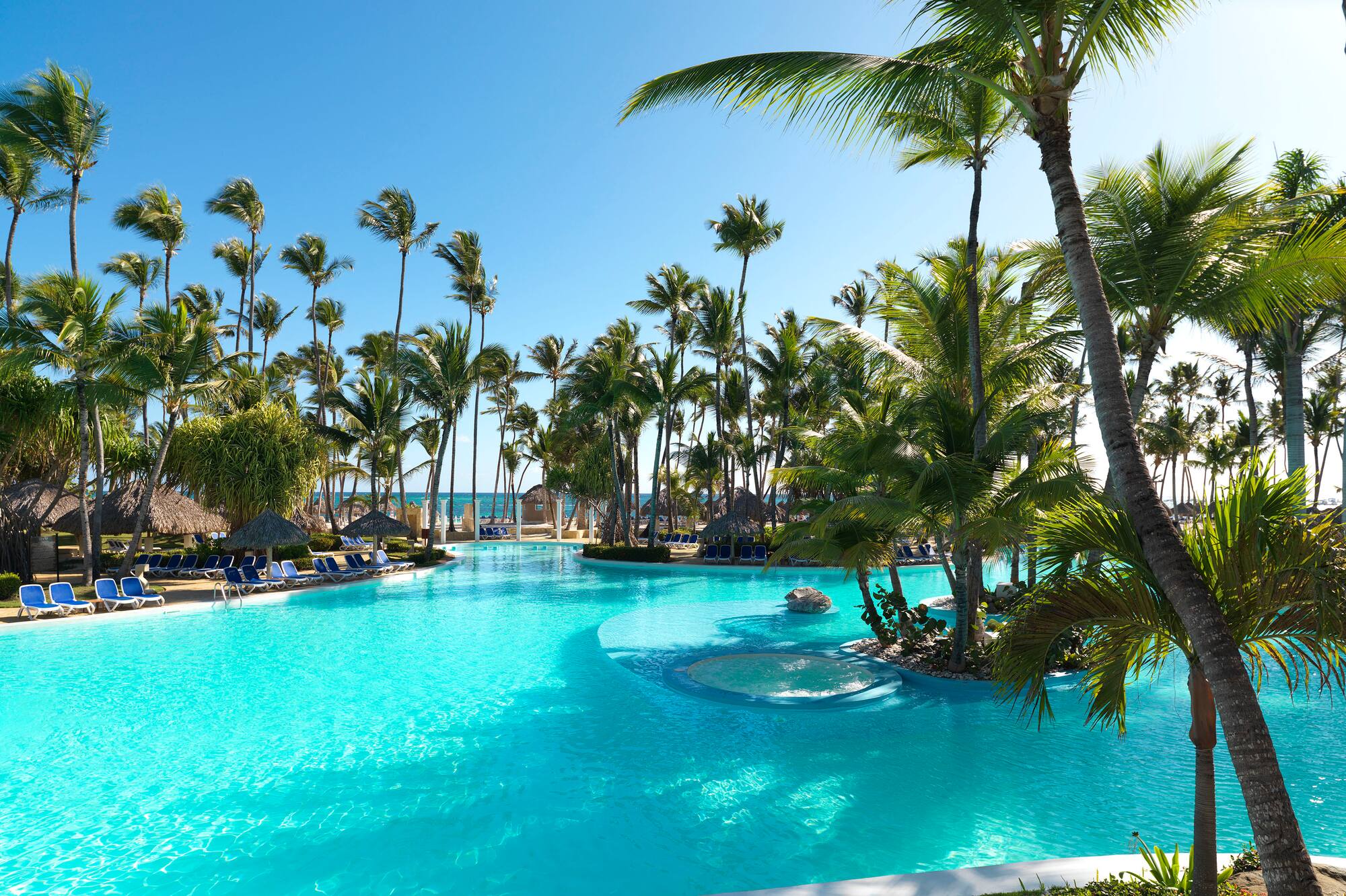 a pool with palm trees and a fountain
