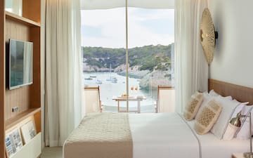 a room with a bed and a view of the water
