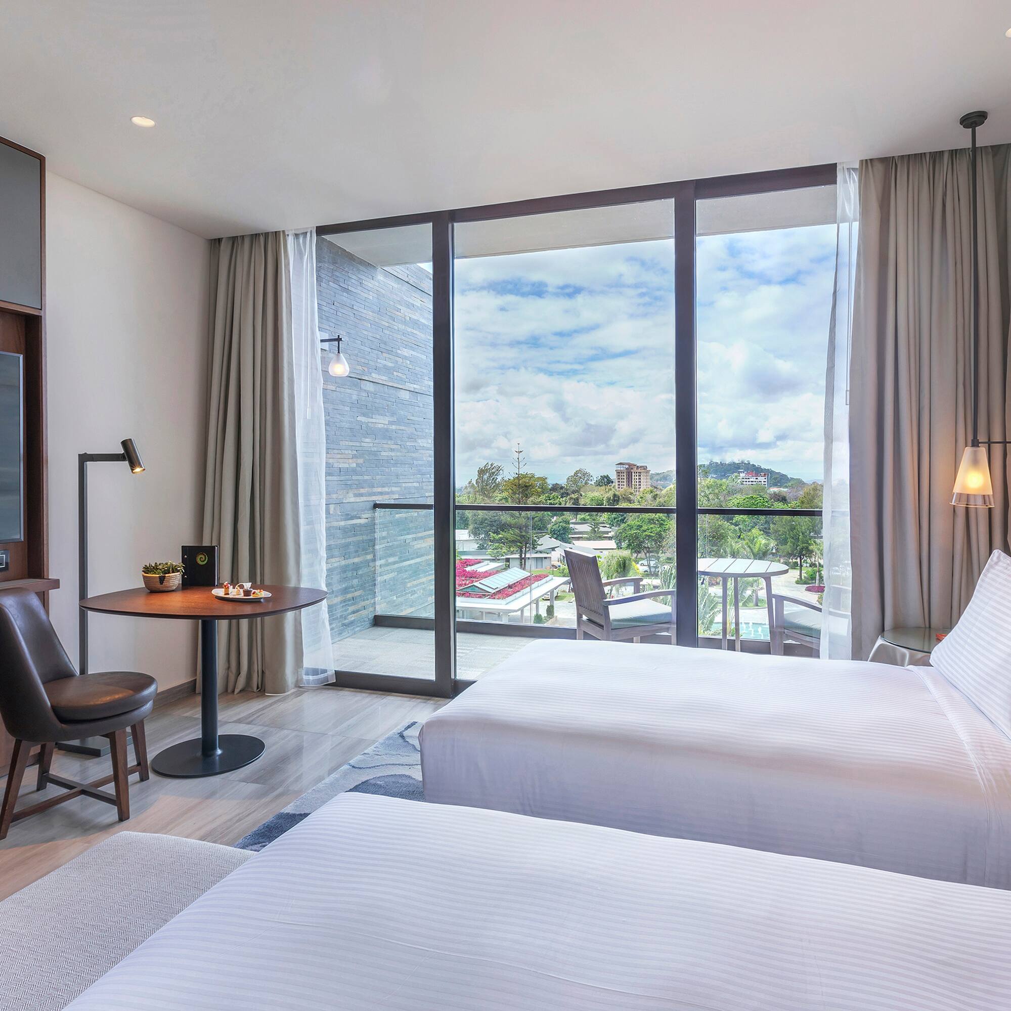 a room with two beds and a table and chairs