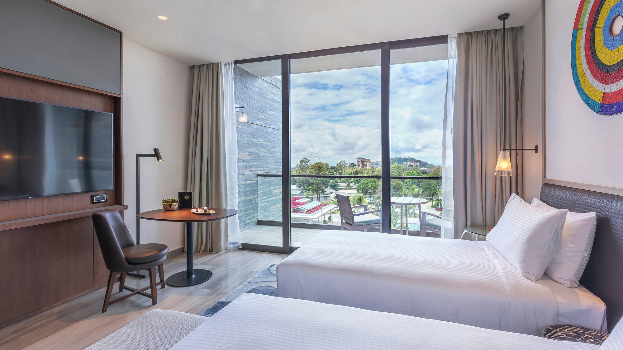 a room with two beds and a table and chairs