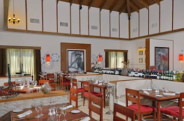 a room with tables and chairs and wine bottles