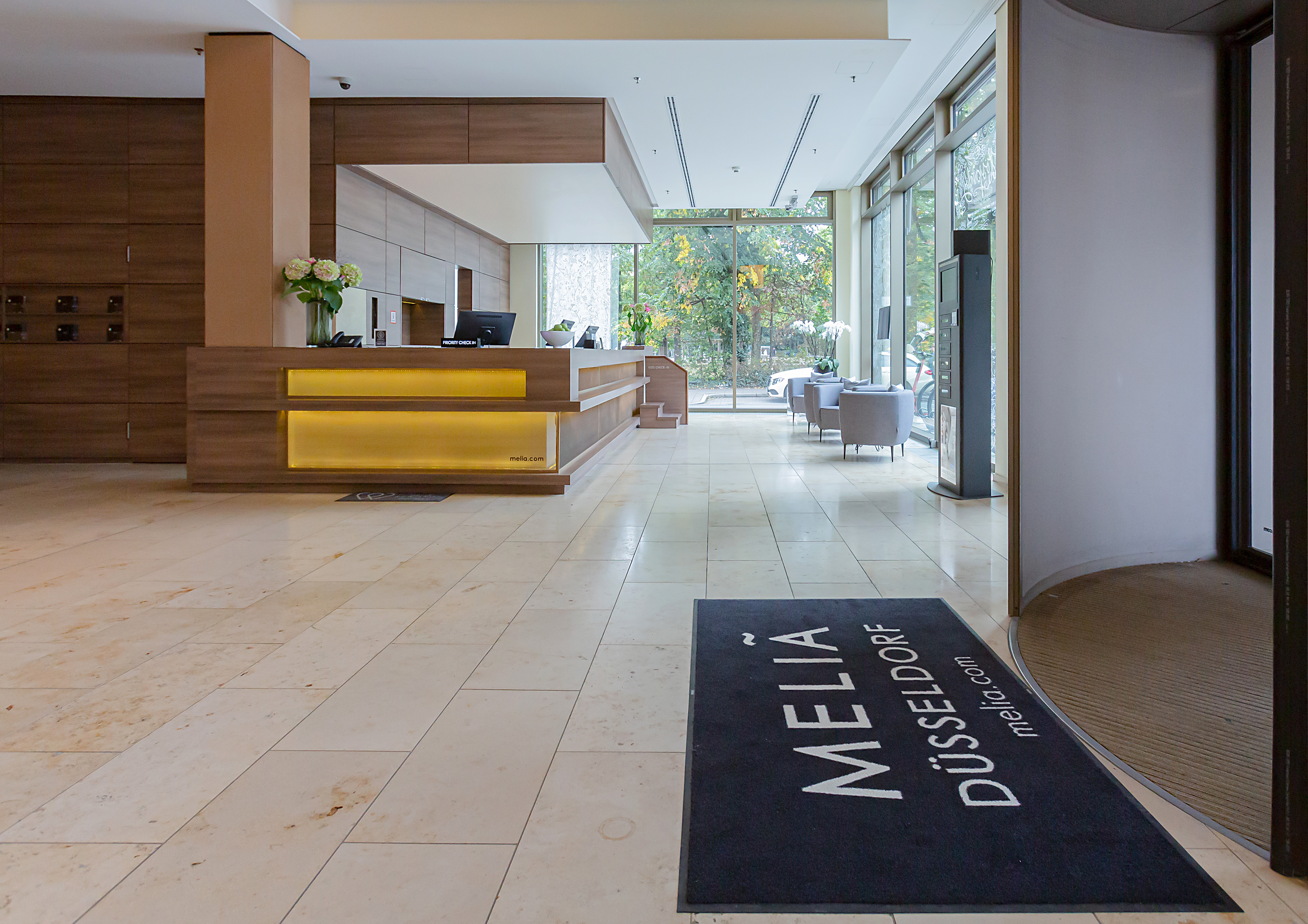 a lobby with a reception desk and a black mat