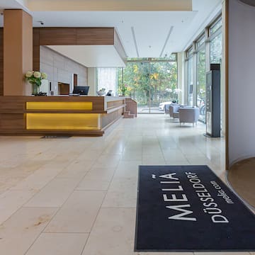 a lobby with a reception desk and a black mat