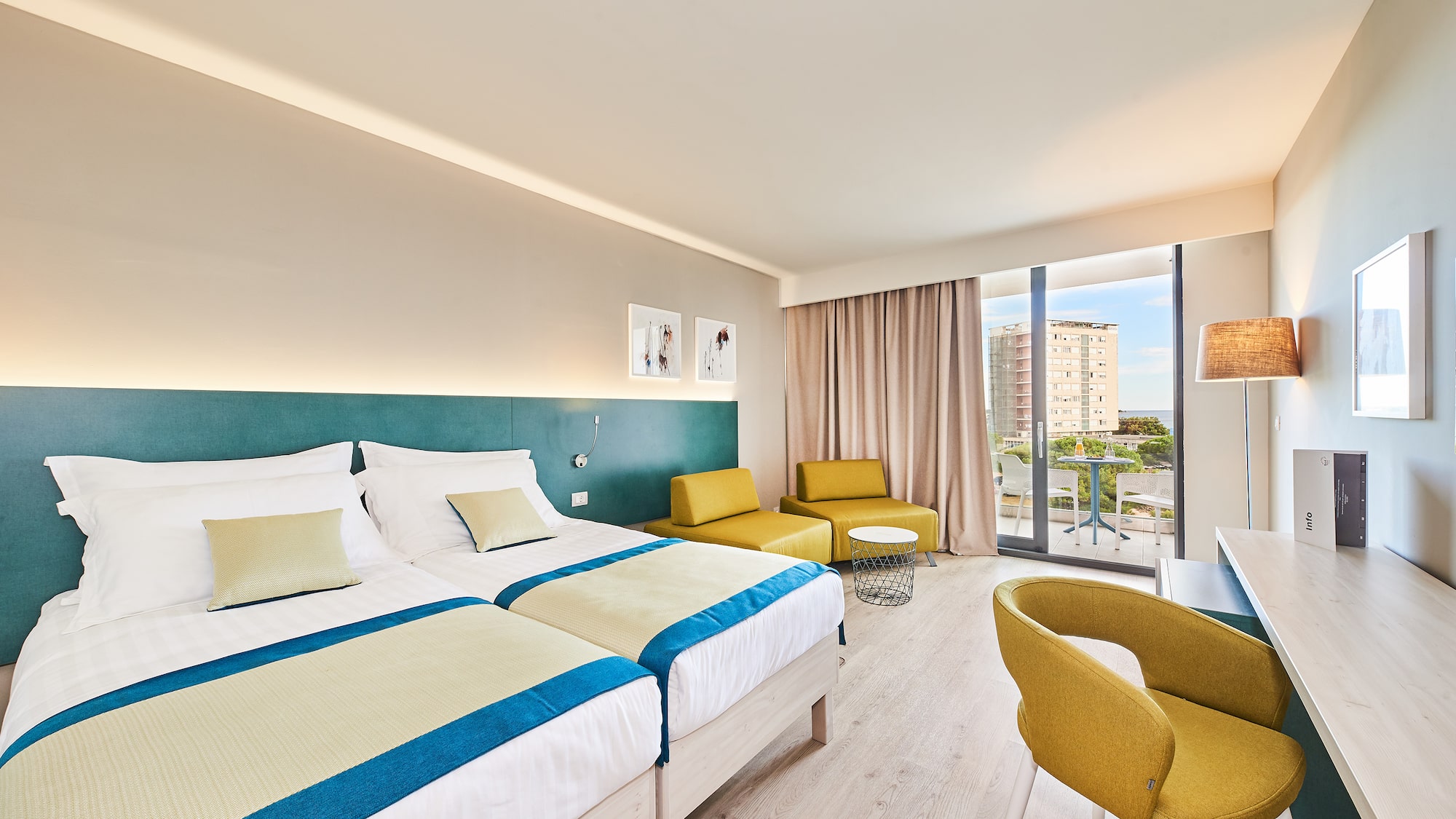 a room with two beds and a table and chairs