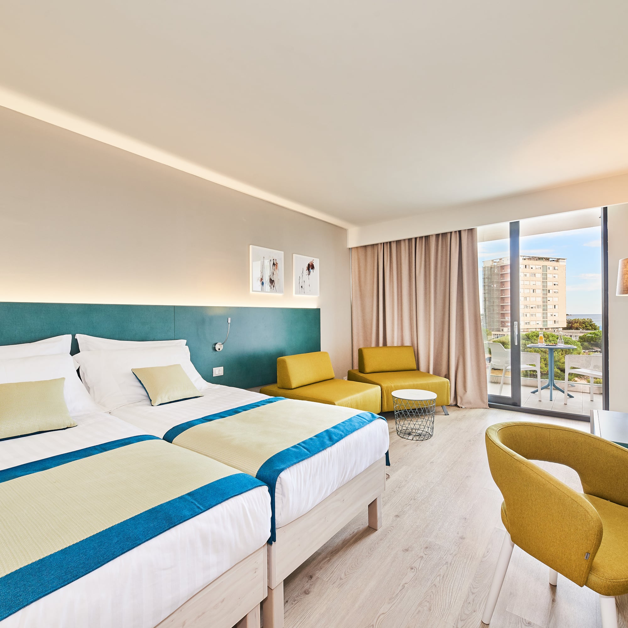 a room with two beds and a table and chairs