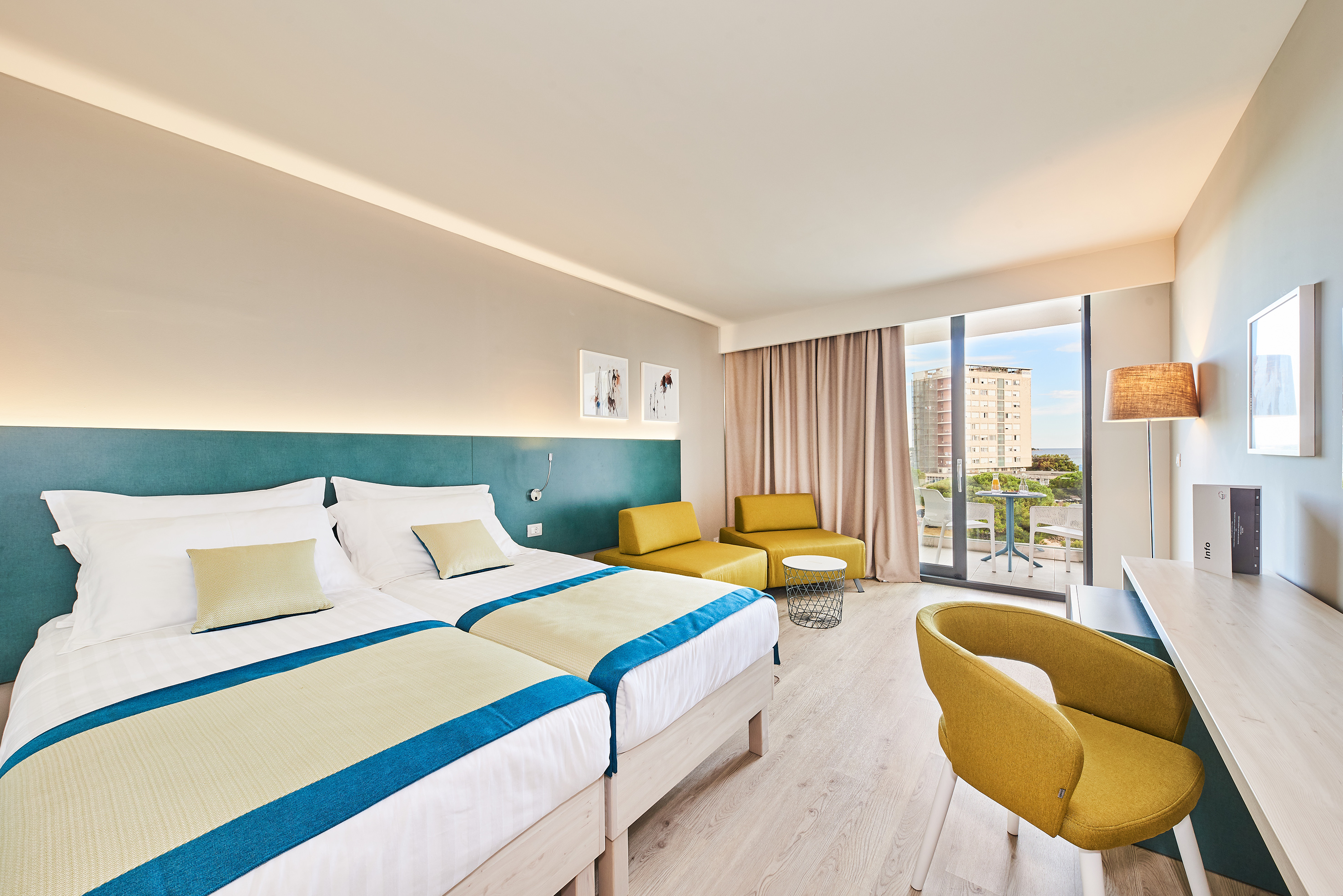 a room with two beds and a table and chairs