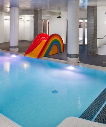 a pool with a slide and a rainbow in the middle