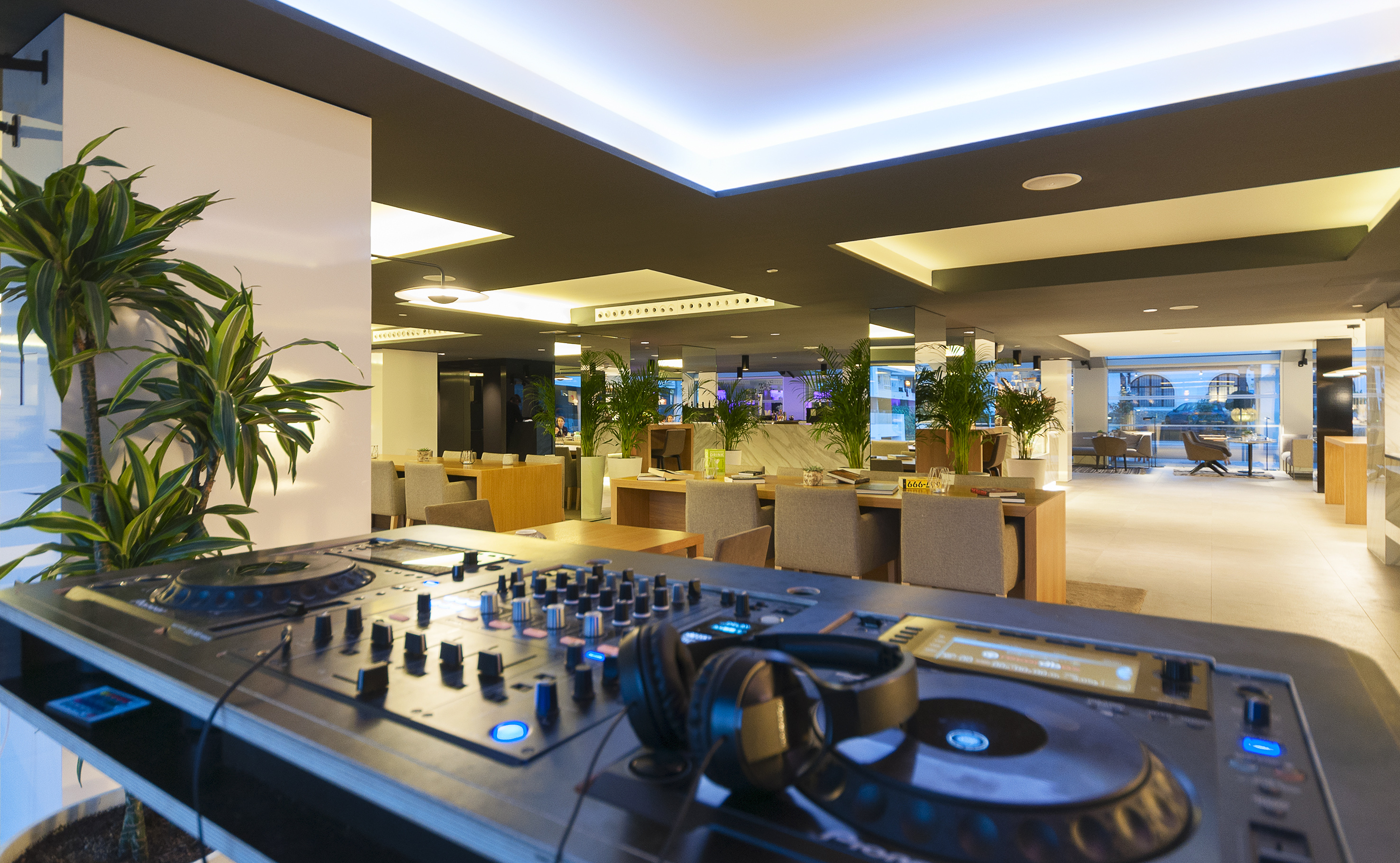 DJ station with headphones in a modern hotel restaurant or bar lounge.