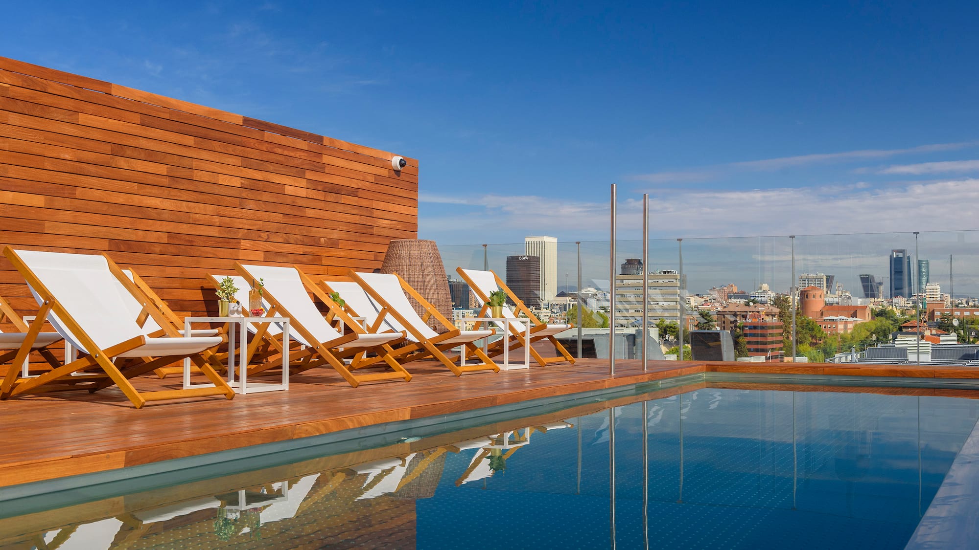 a pool with chairs and a wood wall