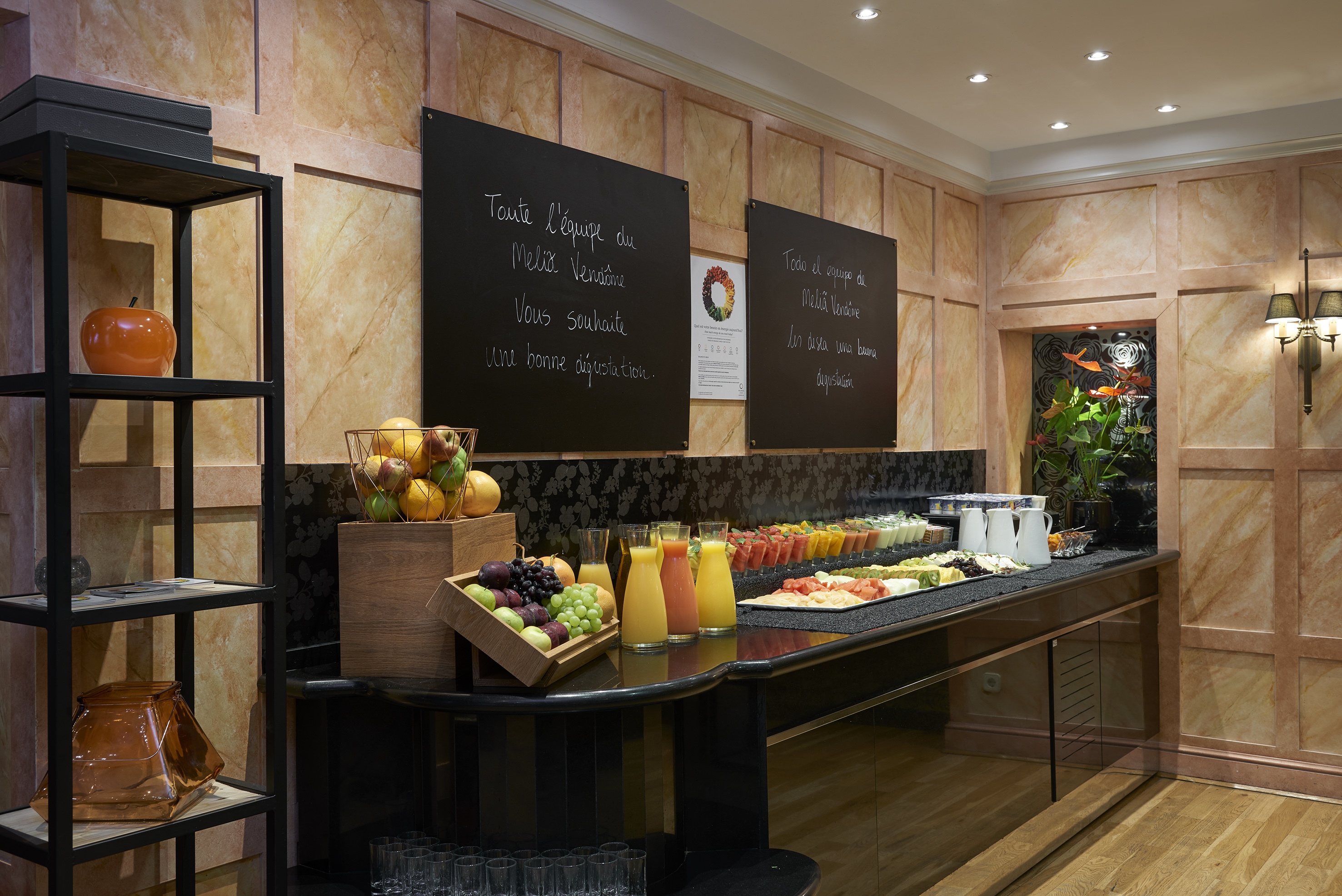 Melia Vendôme hotel breakfast buffet with fresh fruit, juices, and salads.