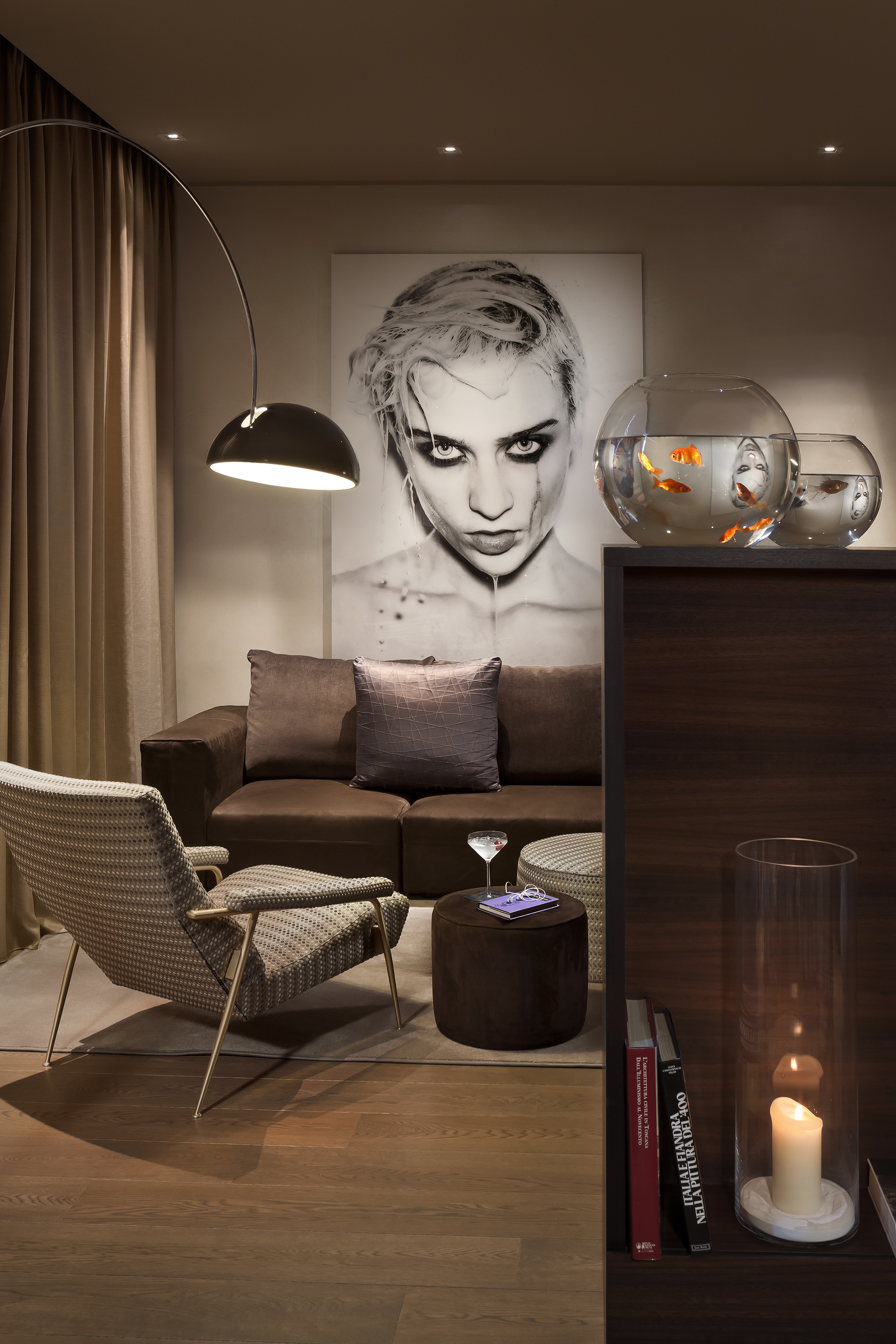 Chic modern living room with sofa, accent chair, arc lamp, bold portrait, fish.