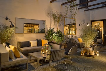 a patio area with chairs and tables and plants