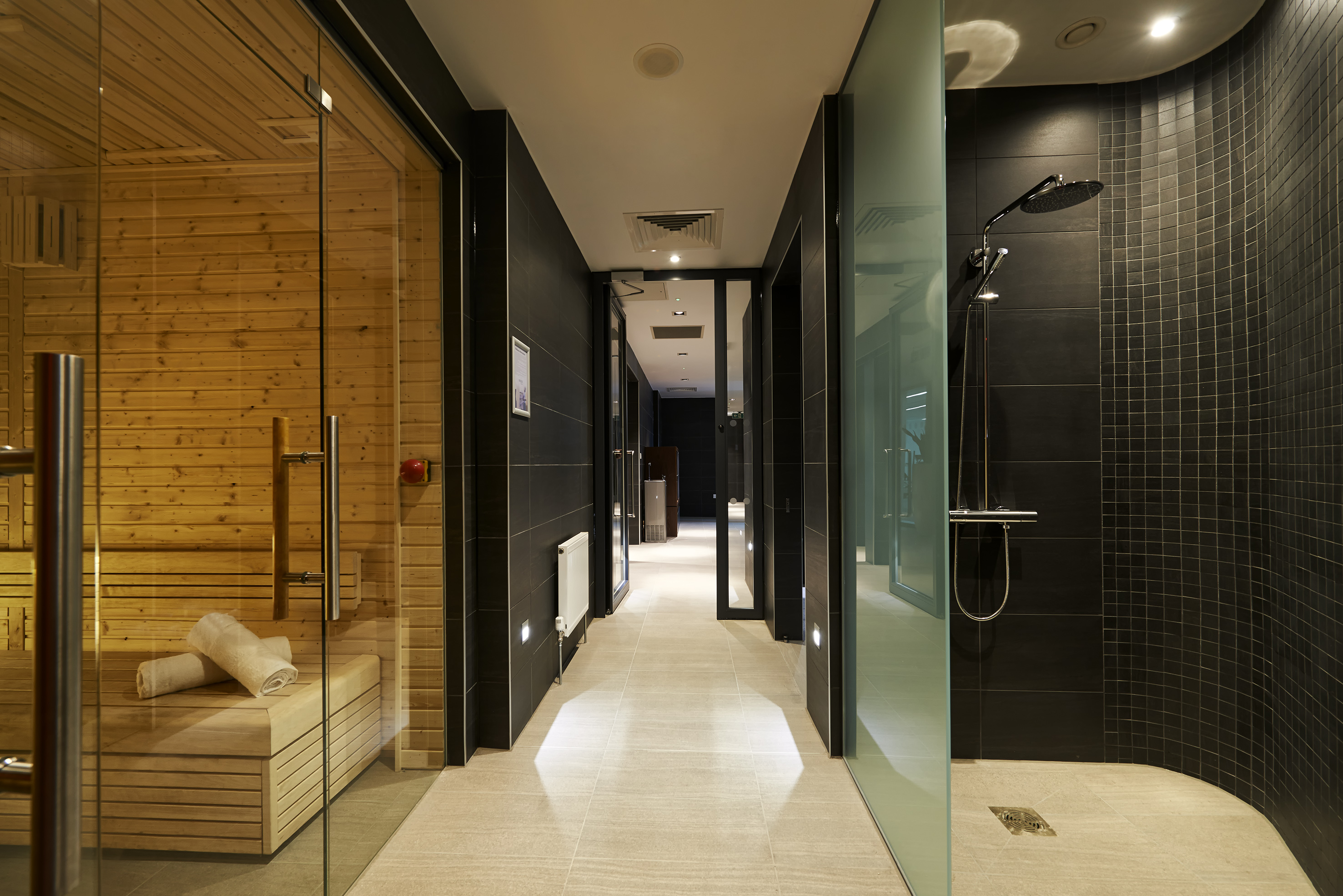 Luxury hotel spa design with sauna, walk-in shower, and stylish hallway.