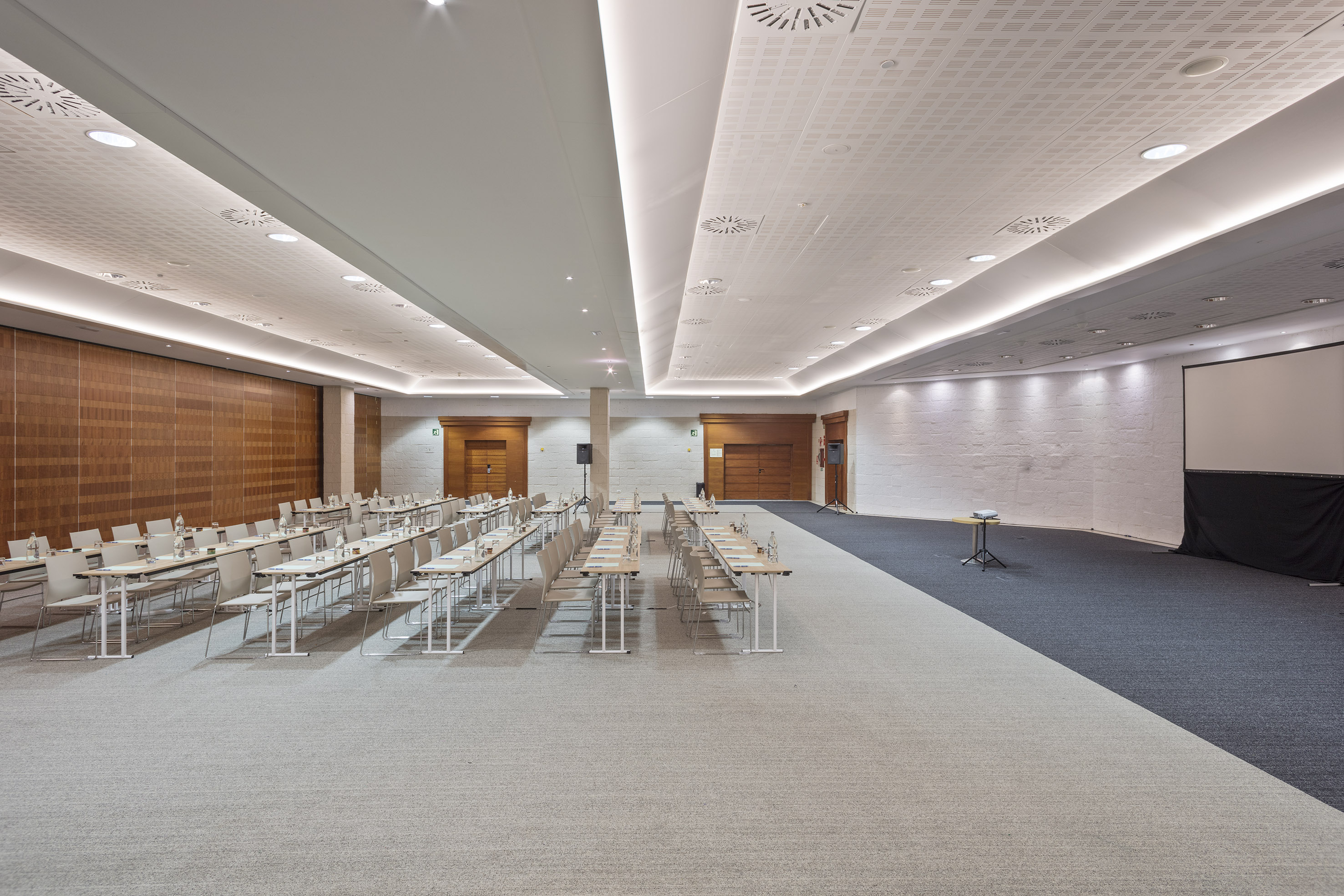 Modern conference room, classroom seating, projector screen.