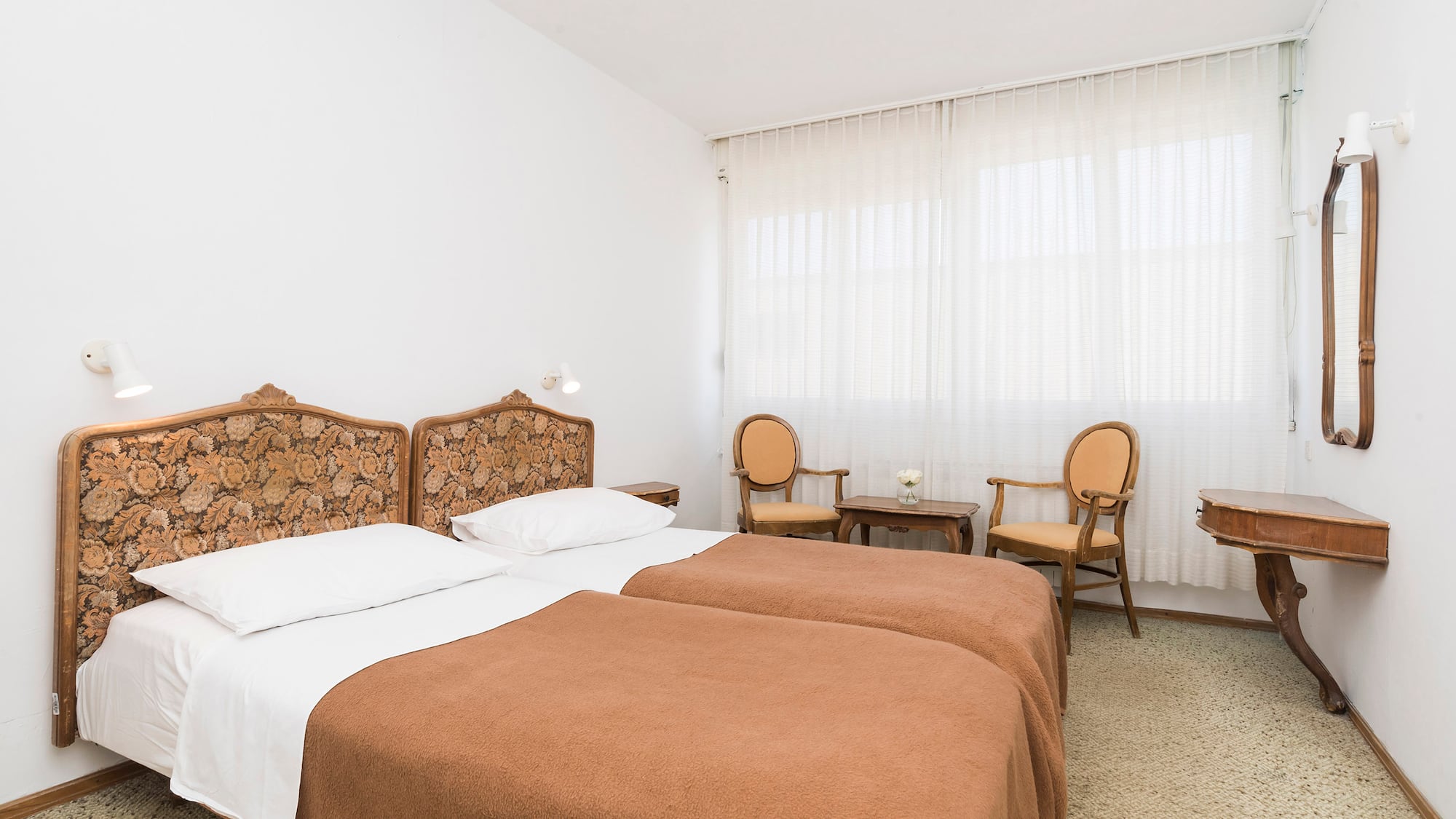 a room with two beds and chairs