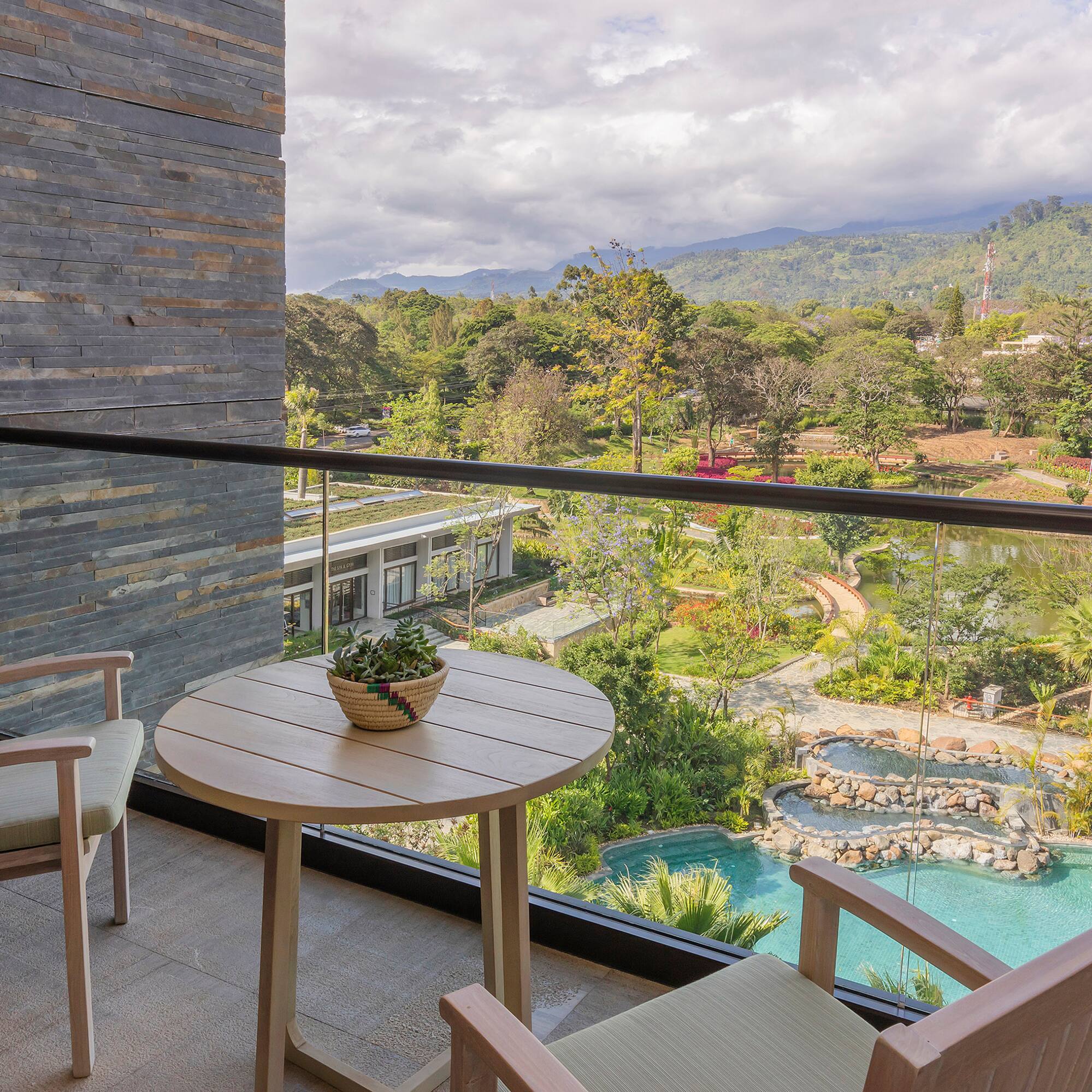 a balcony with a table and chairs and a pool