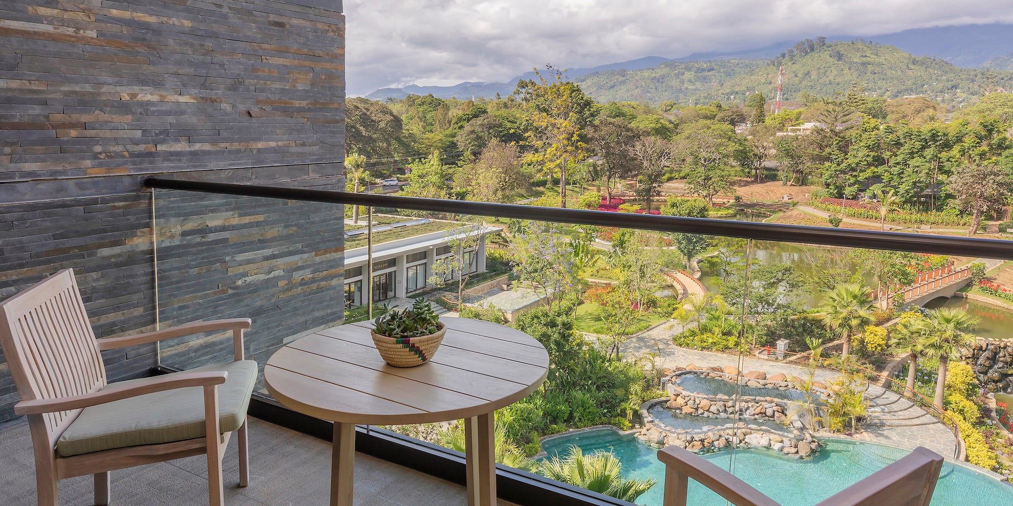 a balcony with a table and chairs and a pool