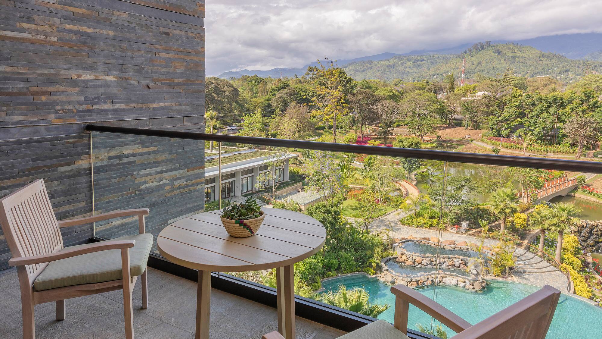 a balcony with a table and chairs and a pool