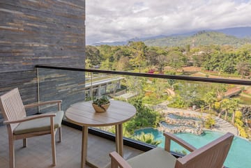 a balcony with a table and chairs and a pool