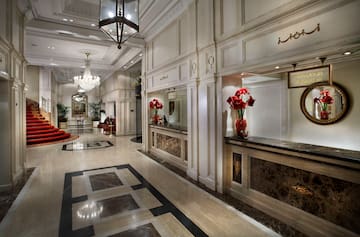 a lobby with marble floor and chandeliers