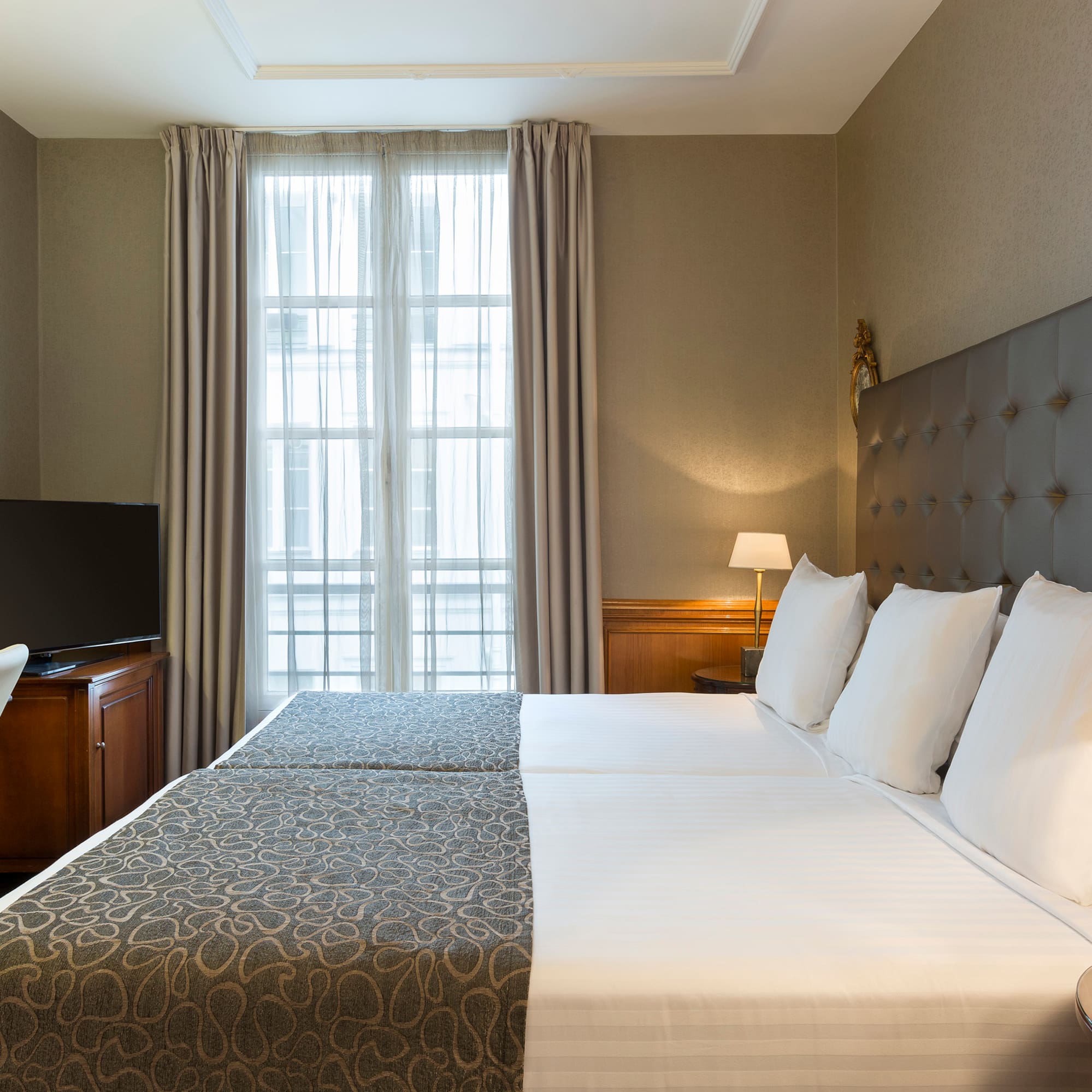 a bed with a tv and a chair in a room